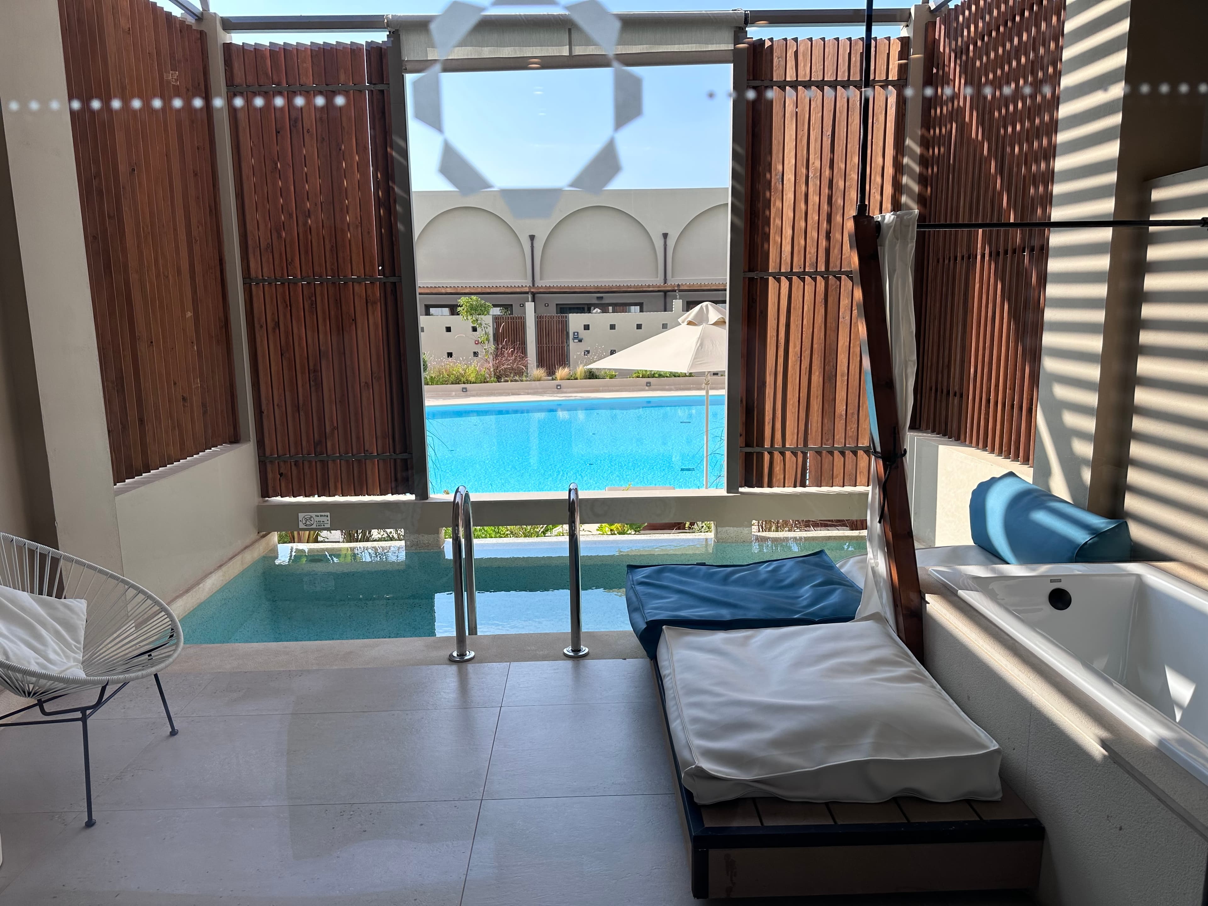 View of a small plunge pool in a cabana besides a larger pool