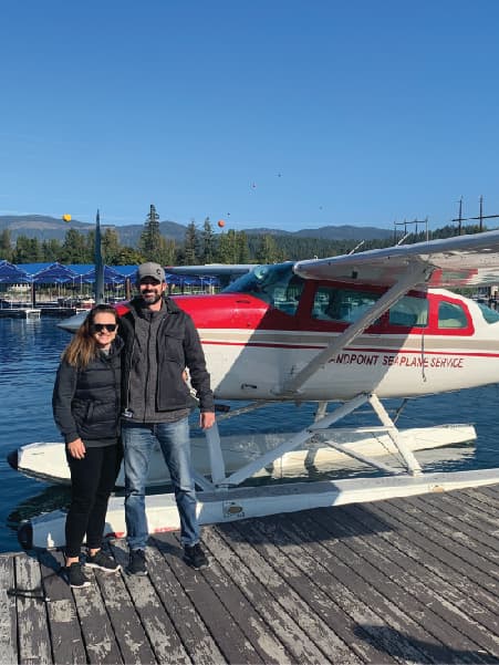 Advisor and partner side by side on a wooden pier in front of seaplane