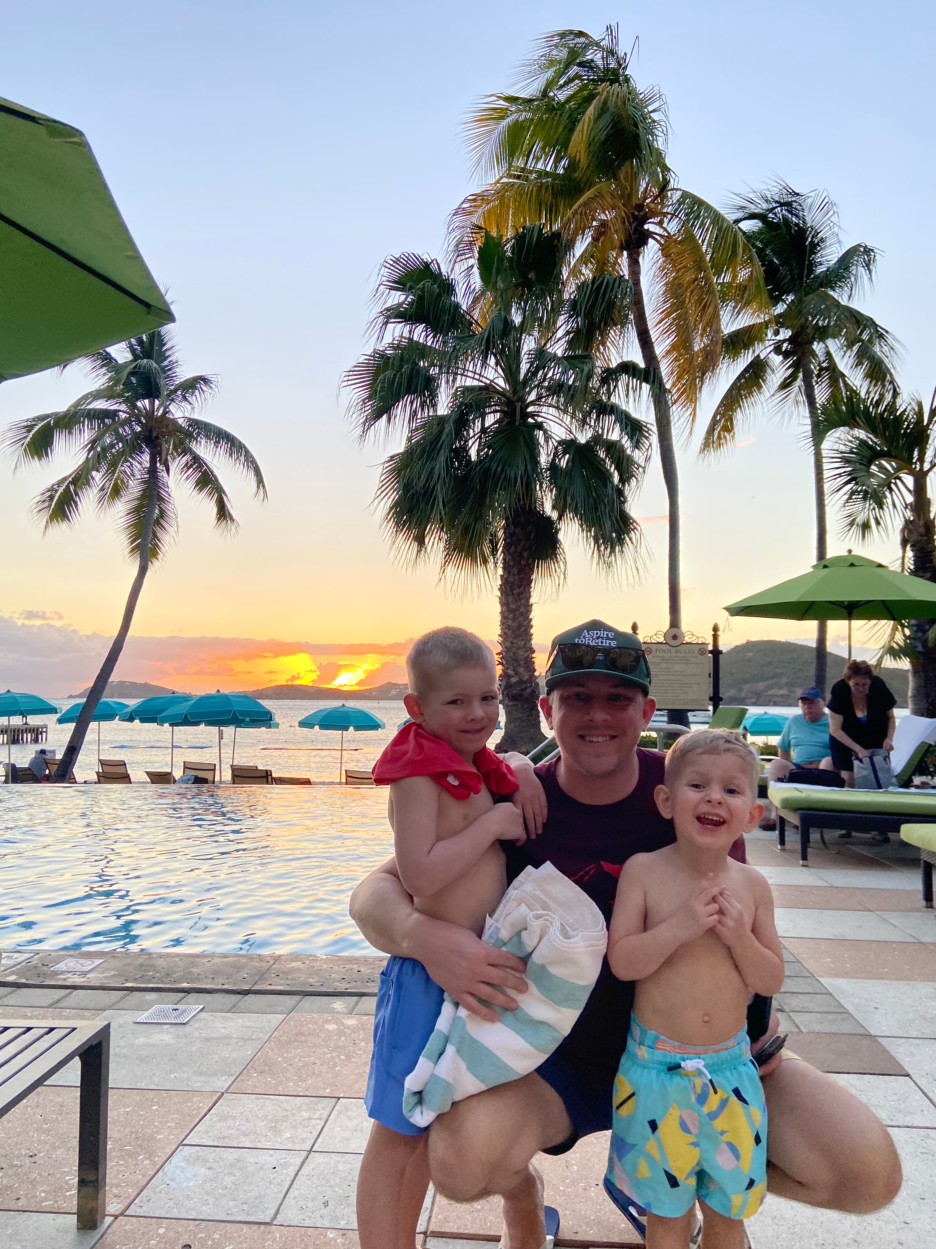 View of advisor’s husband and children by a resort pool at sunset