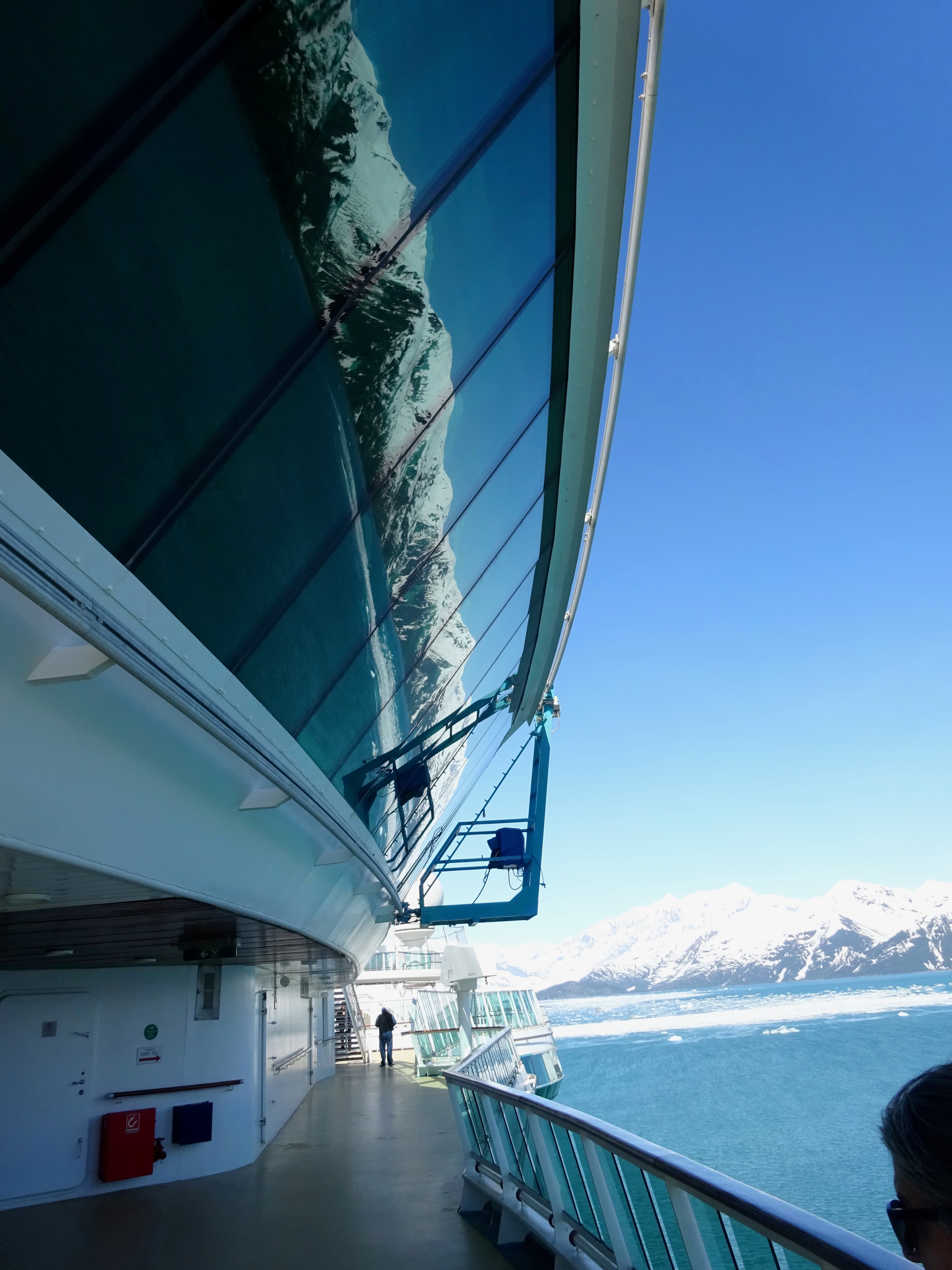 View of the side of a ship sailing through an icy sea on a sunny day