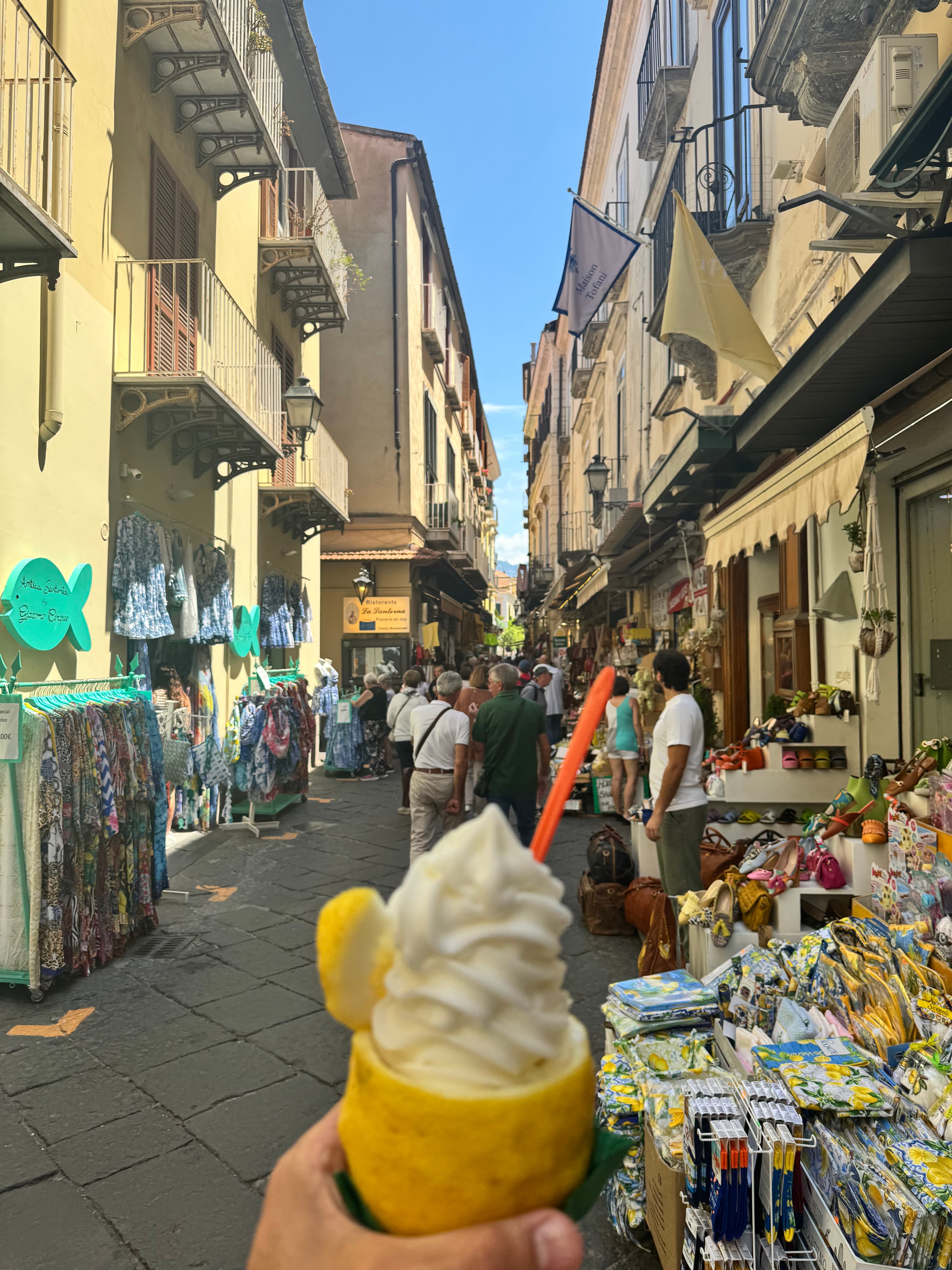 View of a hand holding a lemon sorbet inside a lemon on the street during the day
