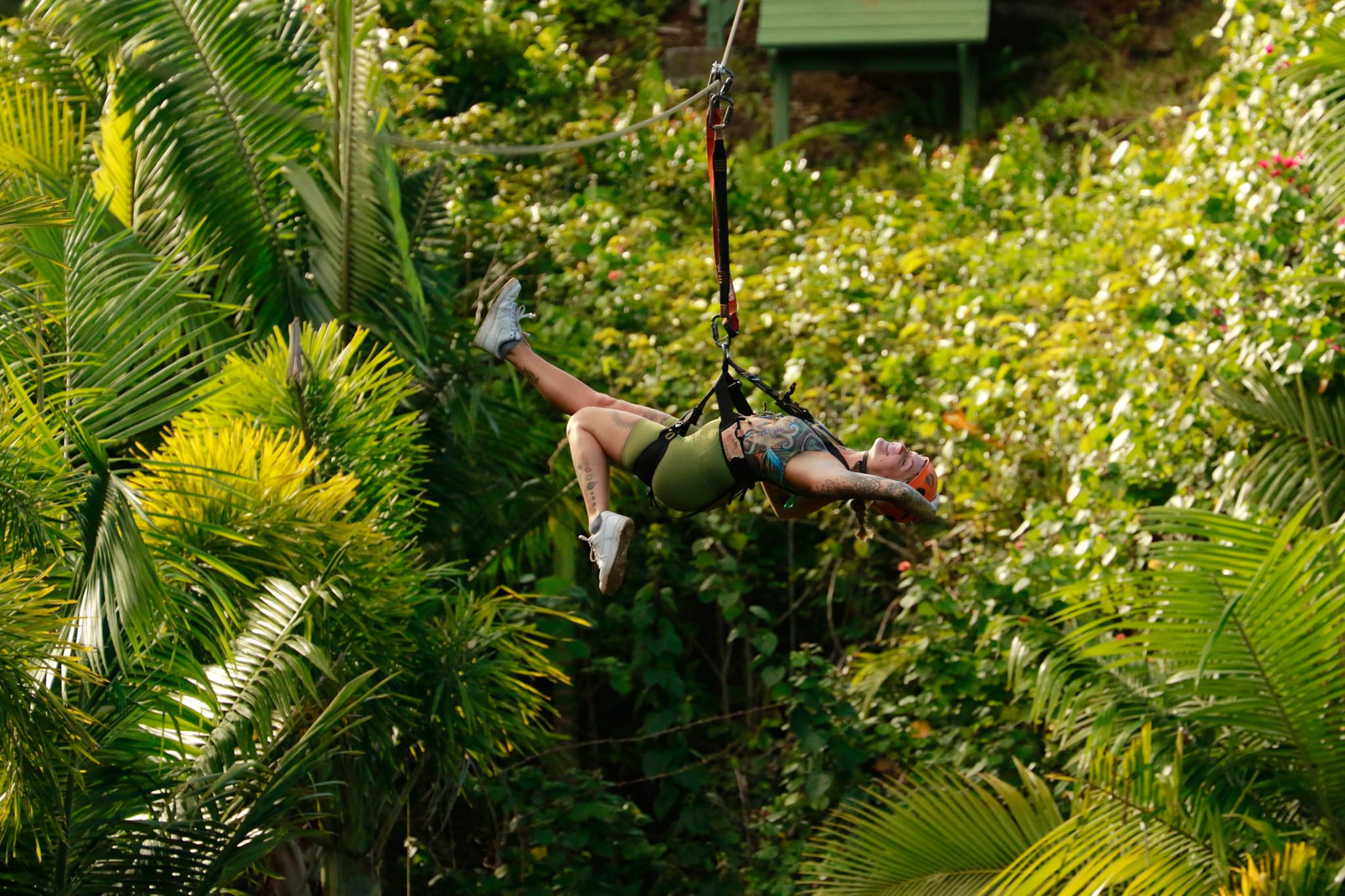 Katie hanging from a zipline out in nature during the daytime.