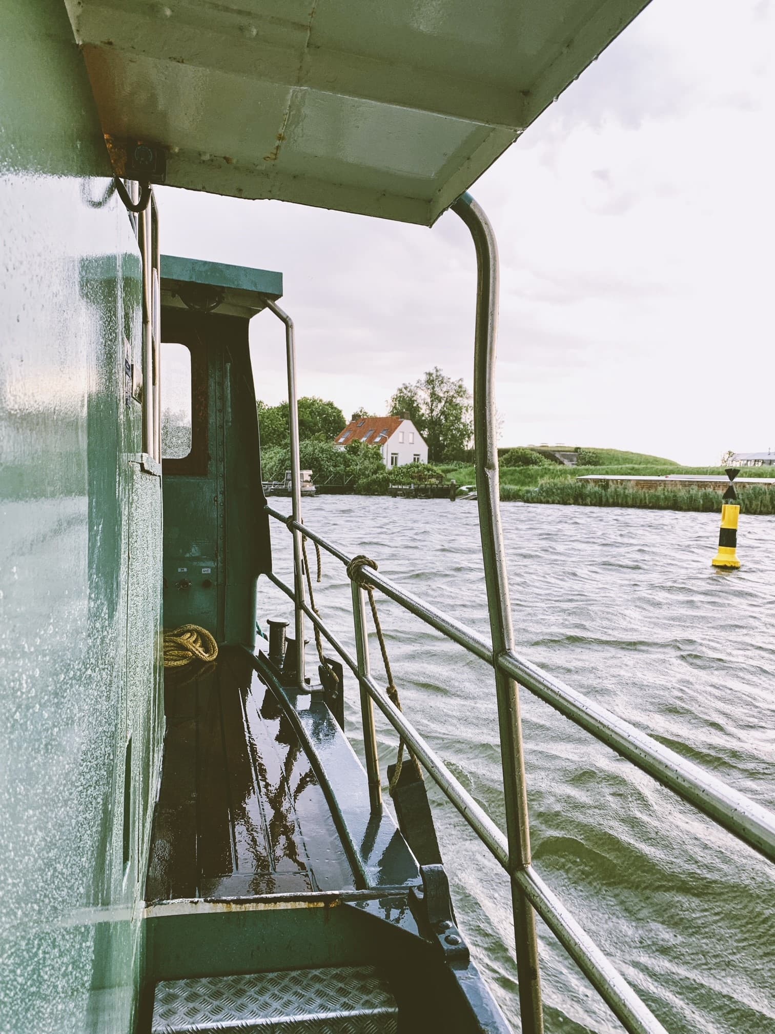 View of the side of a boat at sea on a cloudy day