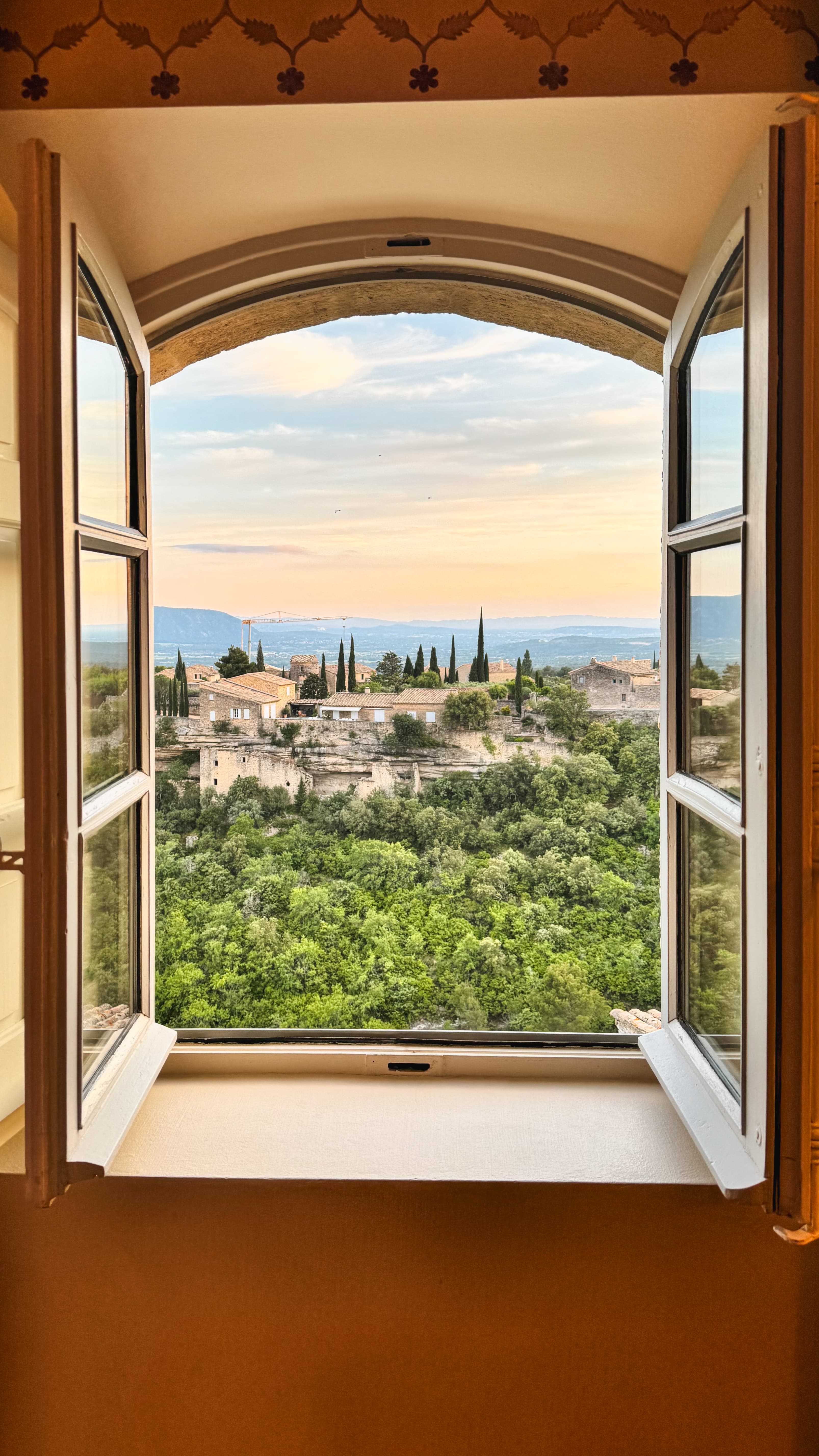 Beautiful countryside landscape seen through an open window at sunset