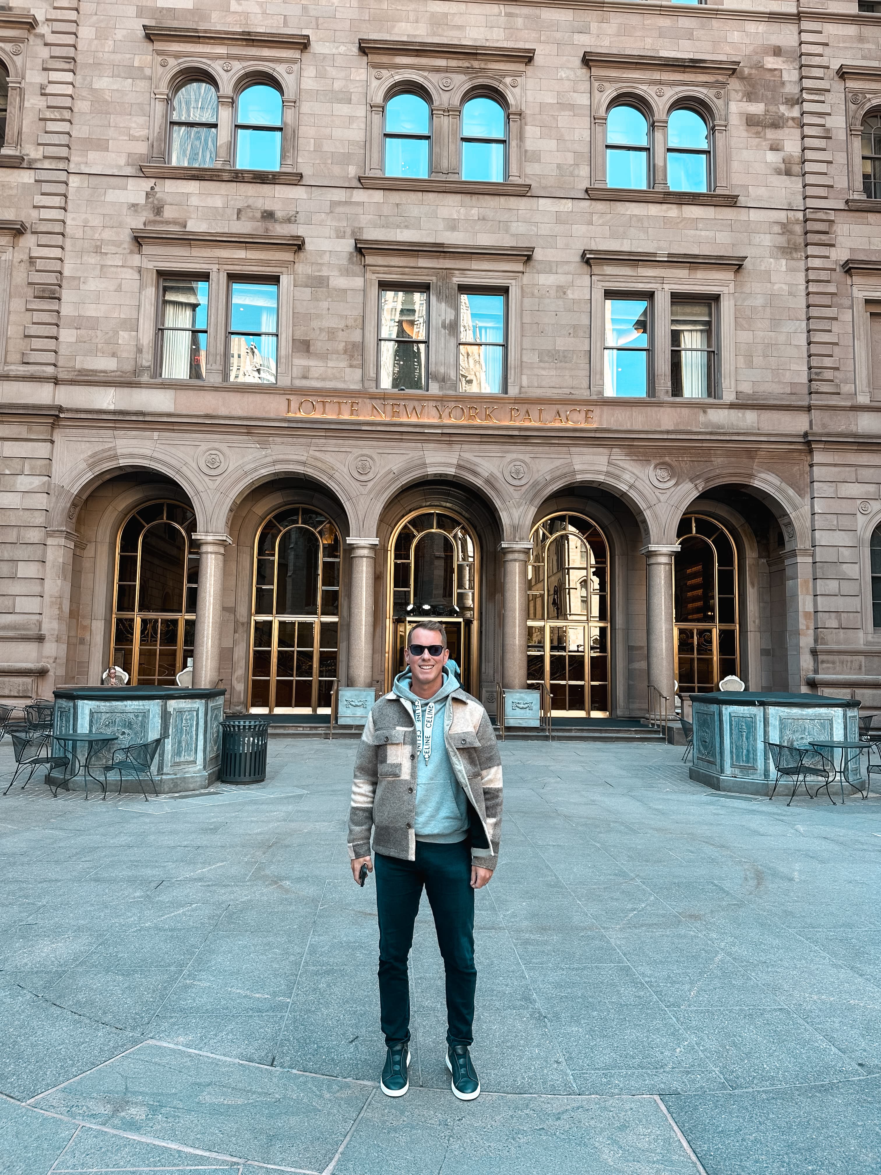 Advisor in a jacket and sunglasses standing in a courtyard with an old building behind him