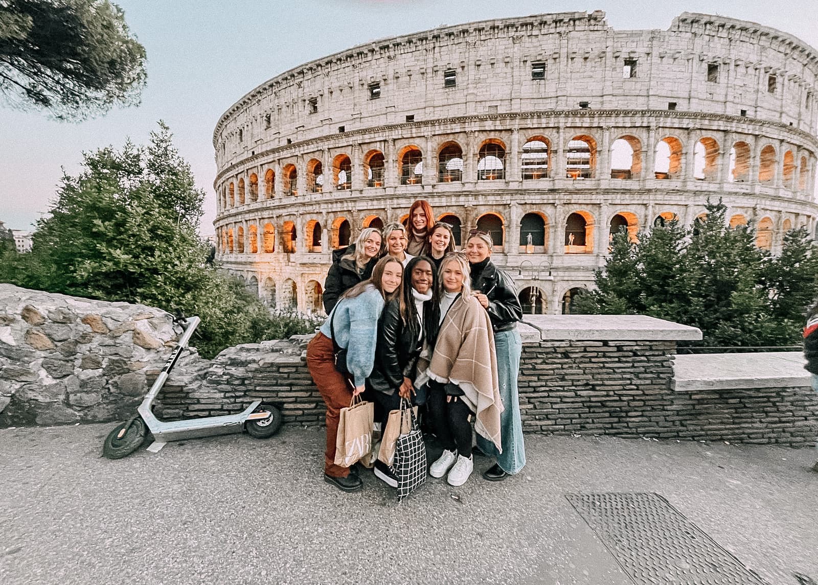 Advisor and friends posing together in front of the Colosseum