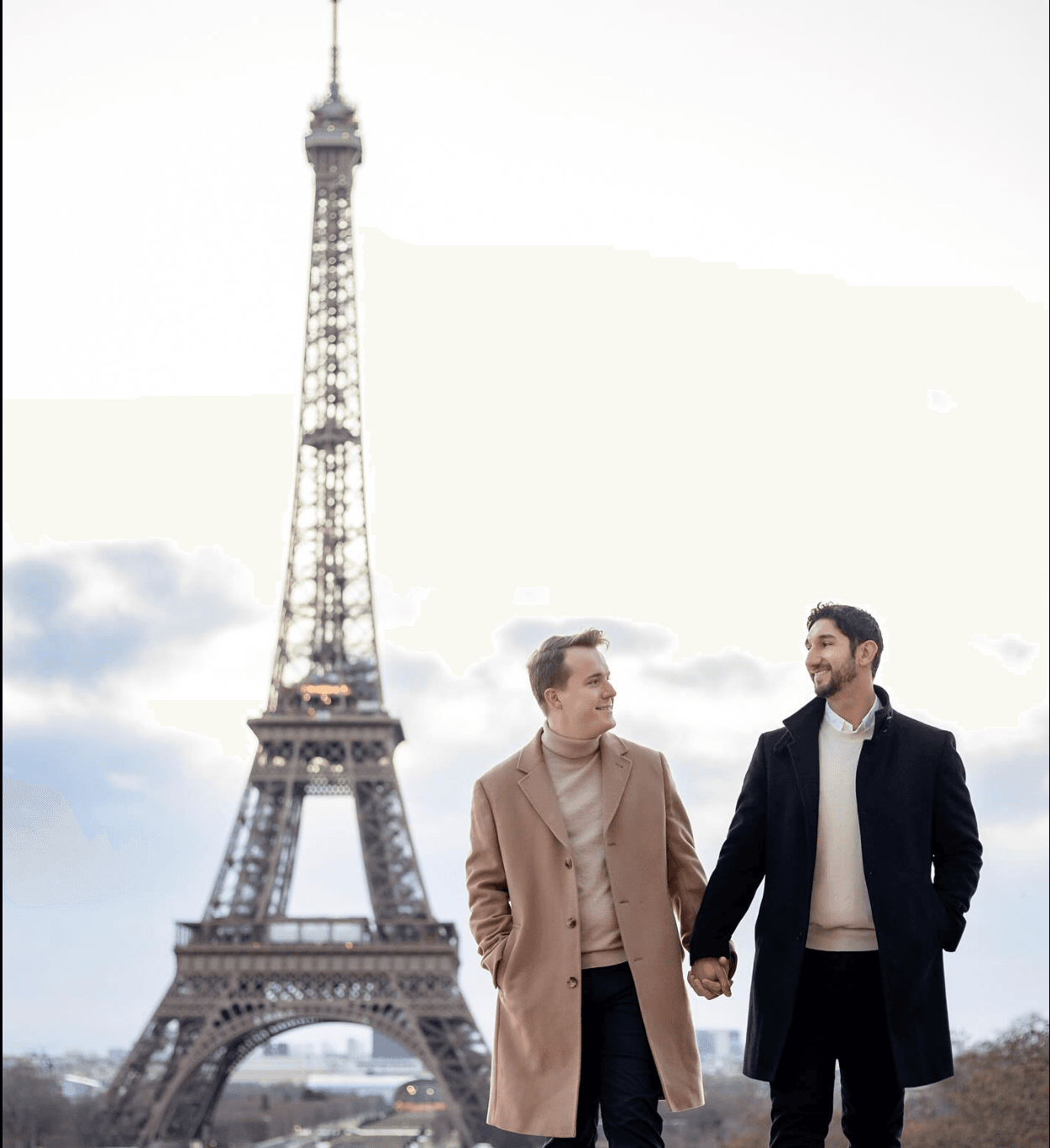 Advisor and partner holding hands with the Eiffel Tower in the background