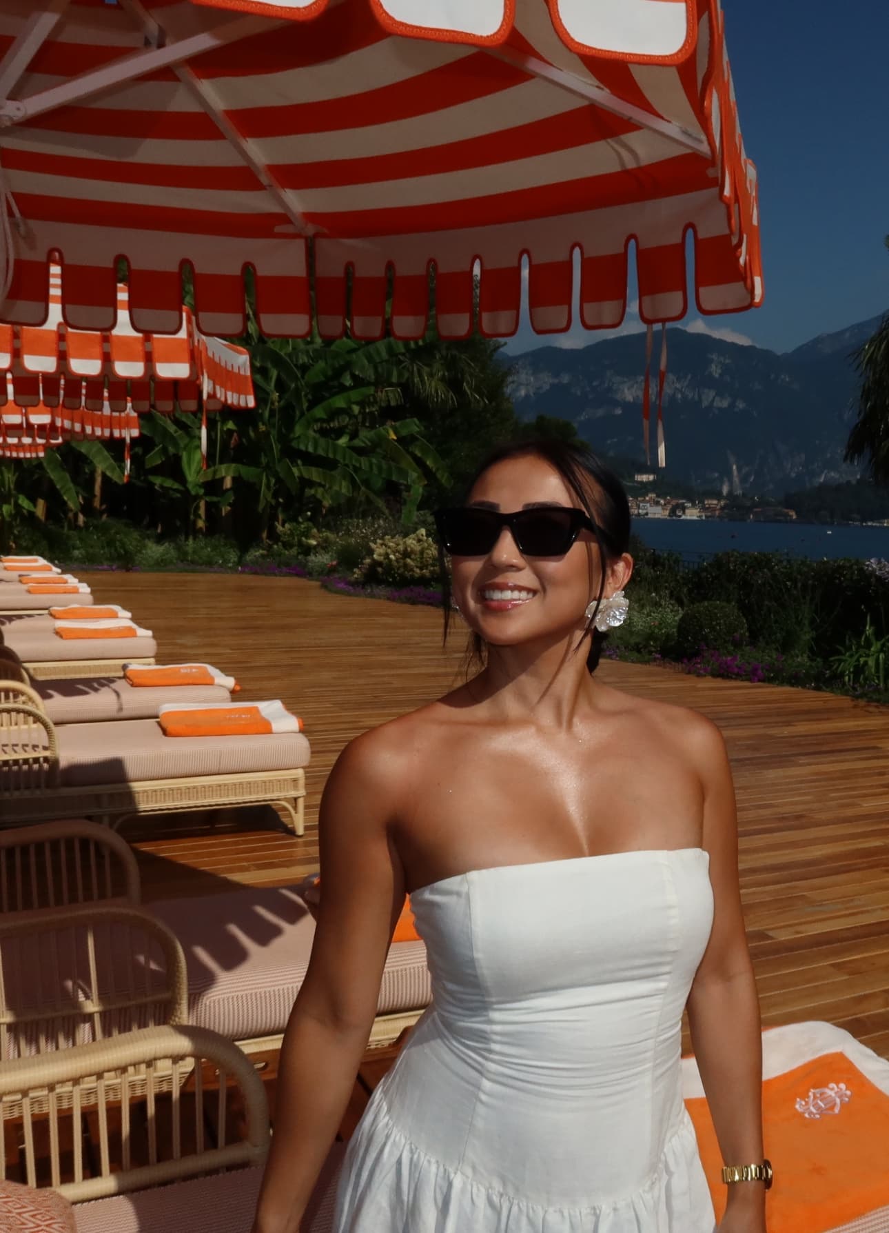 Advisor in a white dress sitting on a lounge chair under a striped umbrella