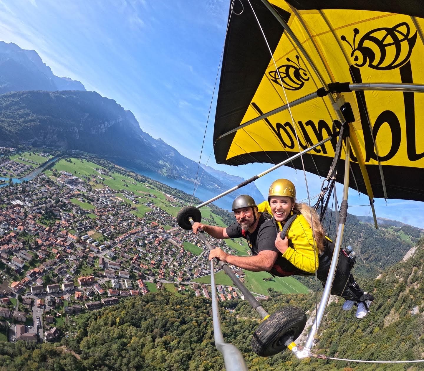 Advisor paragliding over a small town by the sea on a sunny day