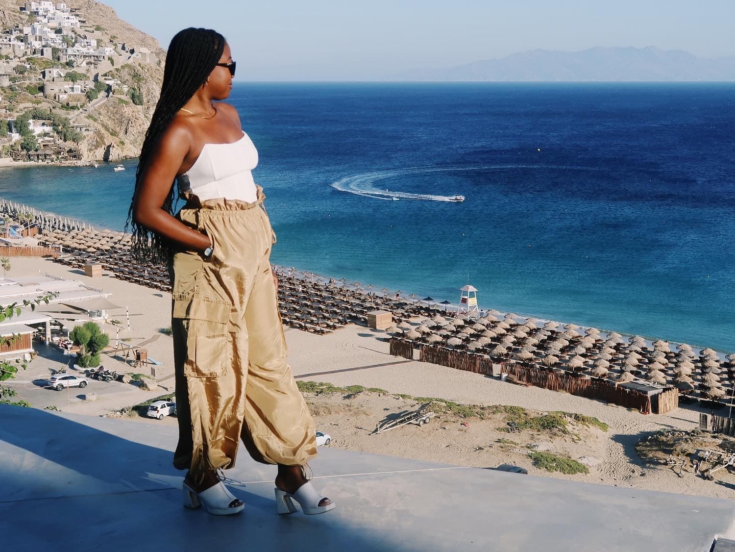 Advisor walking along a platform overlooking a beach with rows of empty lounges and a deep blue sea