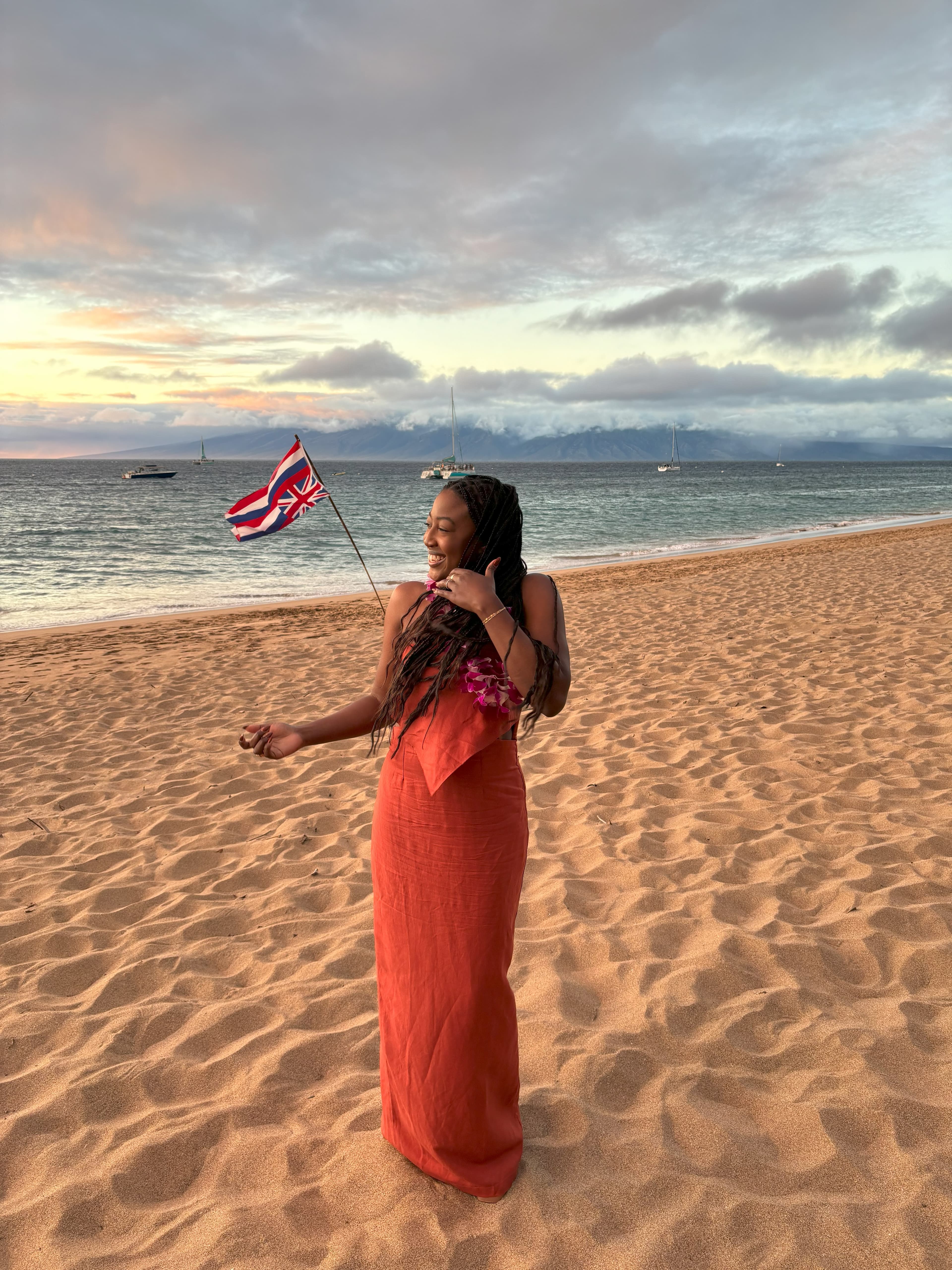 Advisor standing on a beautiful beach in a long dress at sunset
