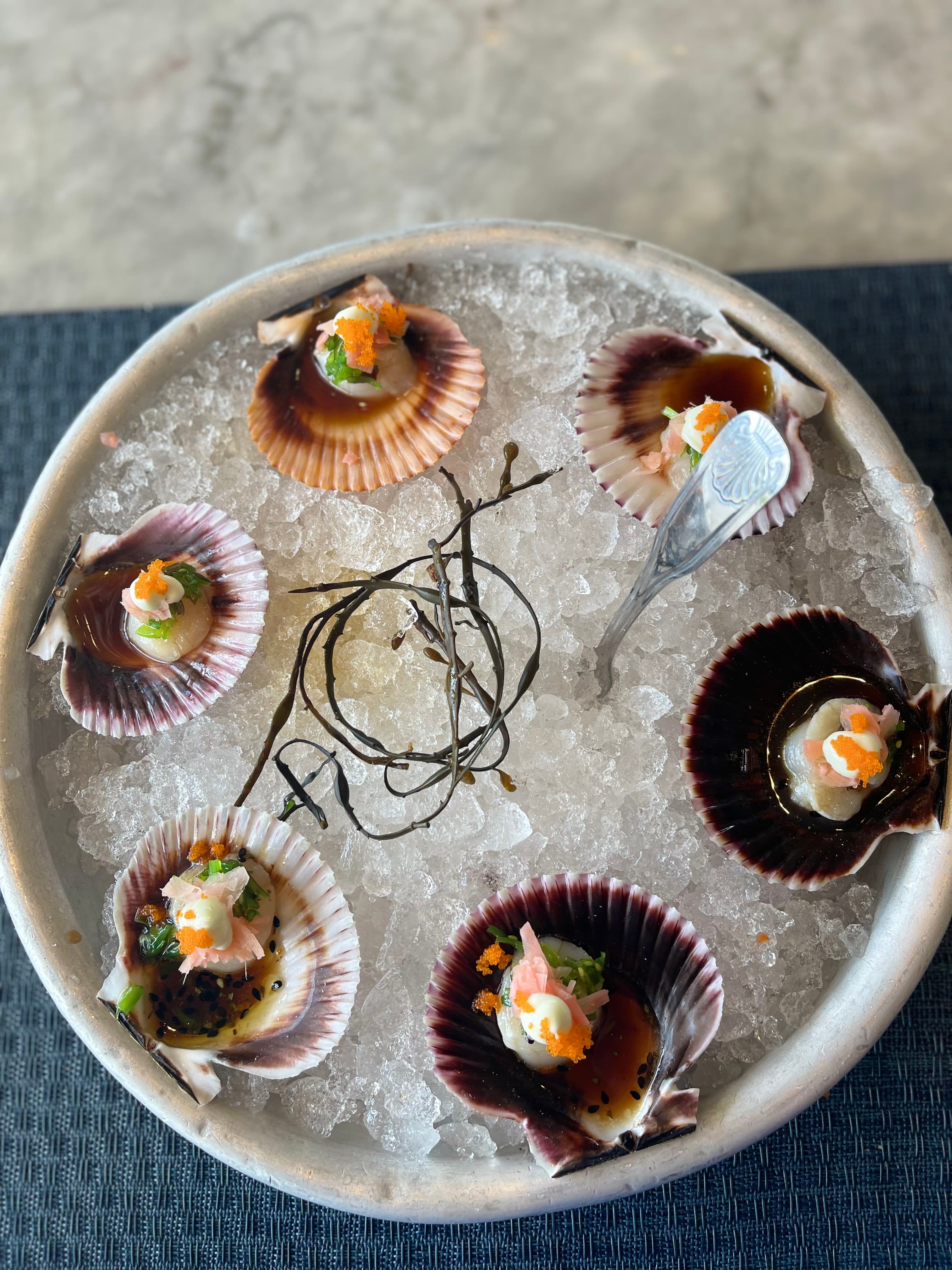 View of a plate of six oysters on ice in a circular dish
