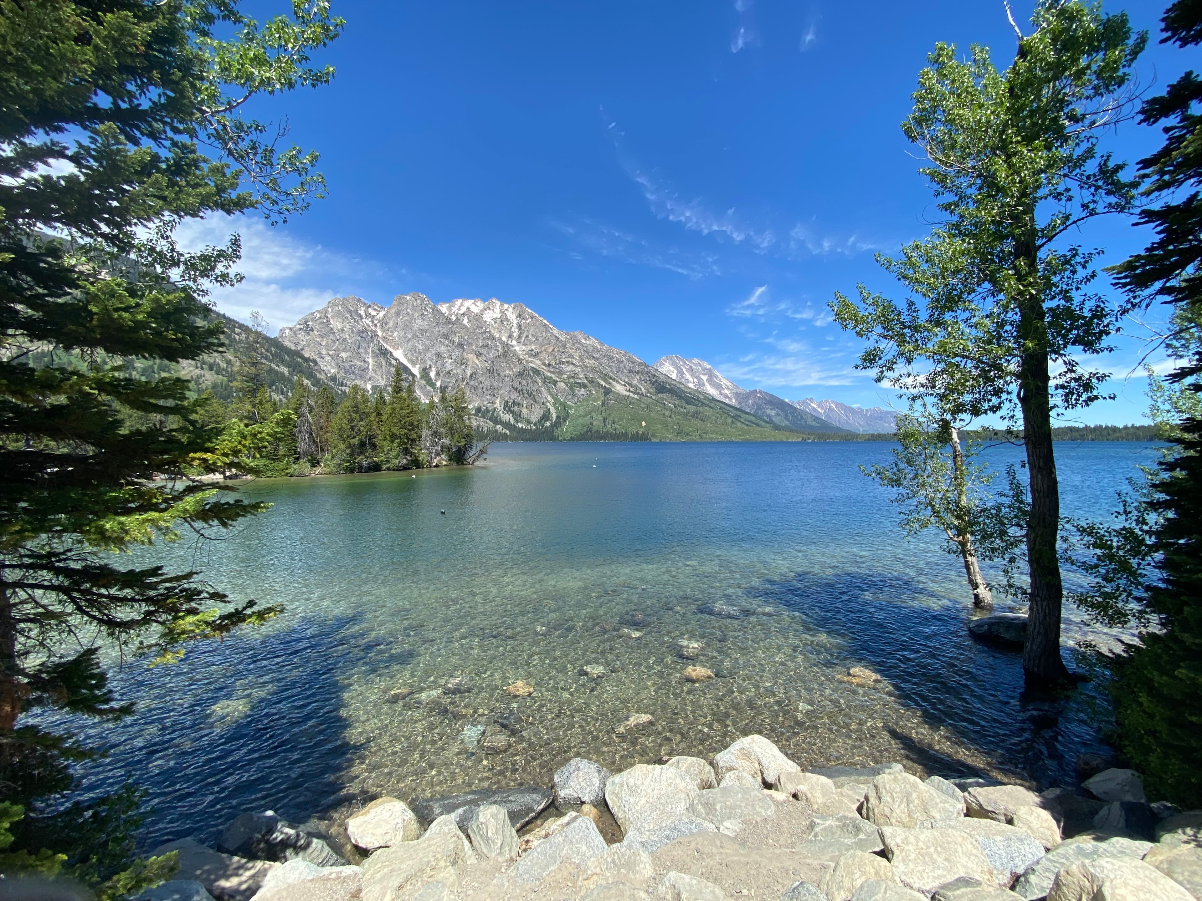 Clear water by mountains.
