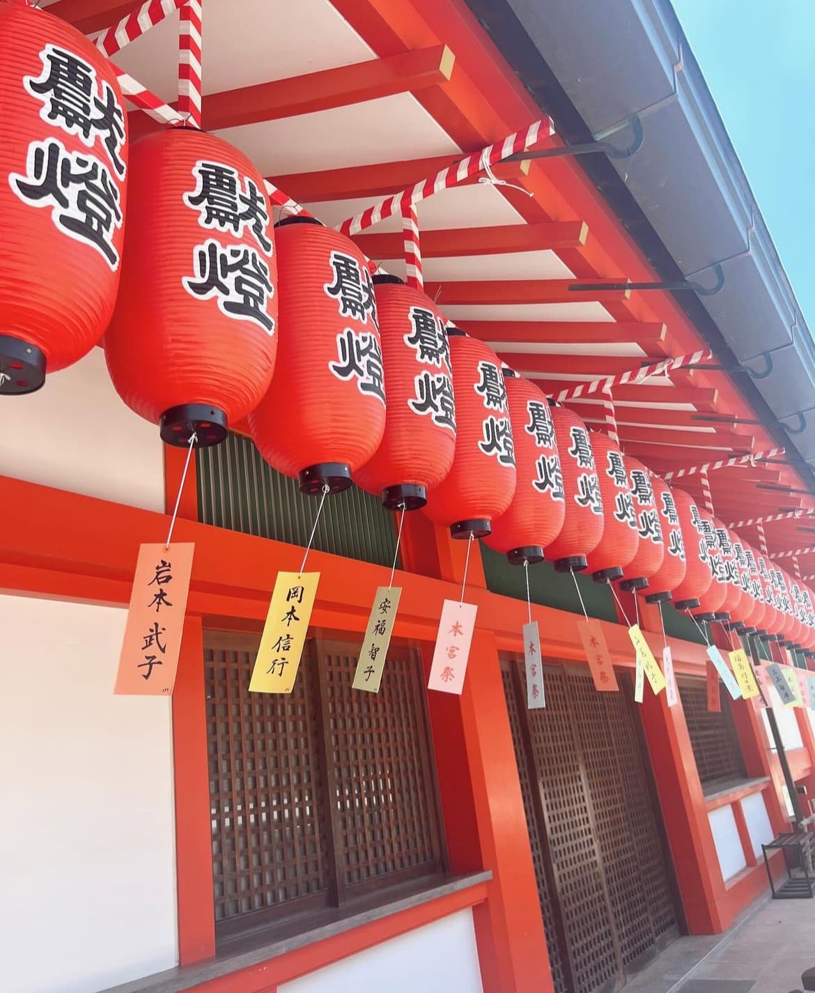 View of red Japanese lanterns hanging in a row on a sunny day