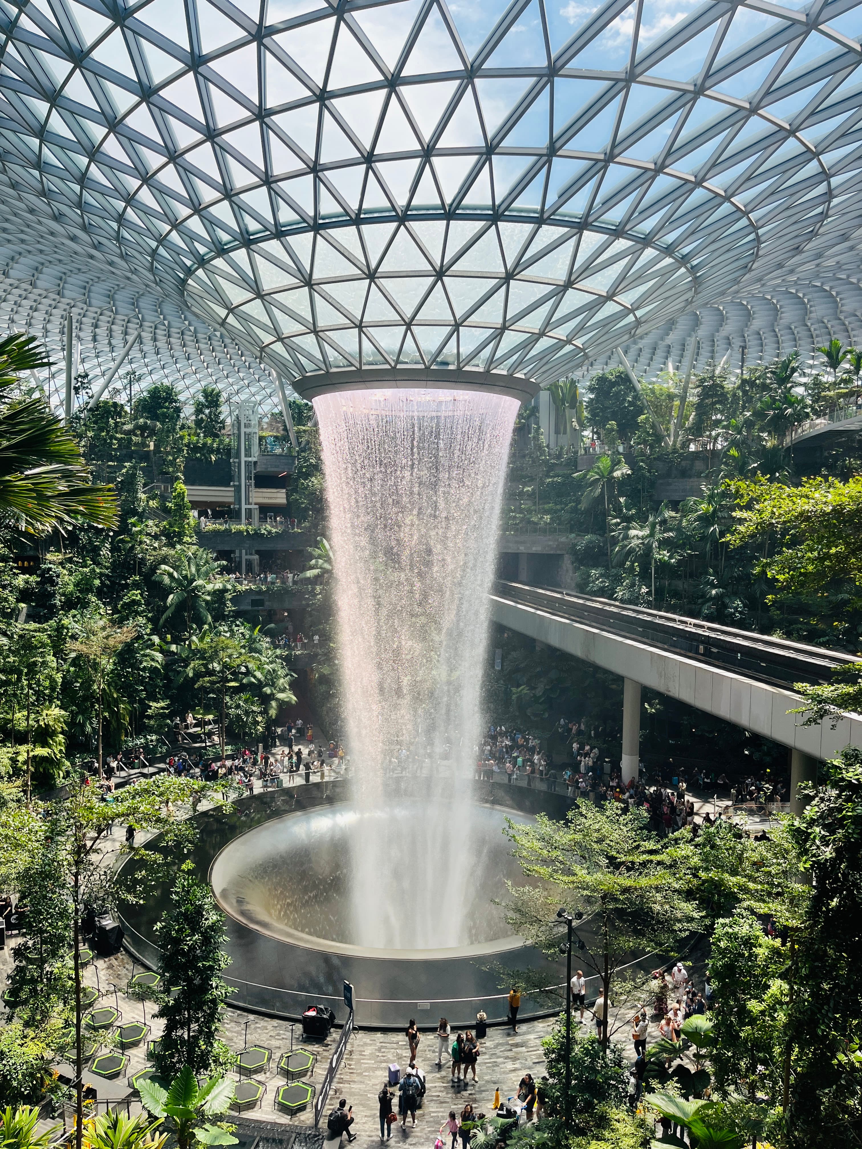 View of the circular waterfall and surrounding plants inside Singapore airport