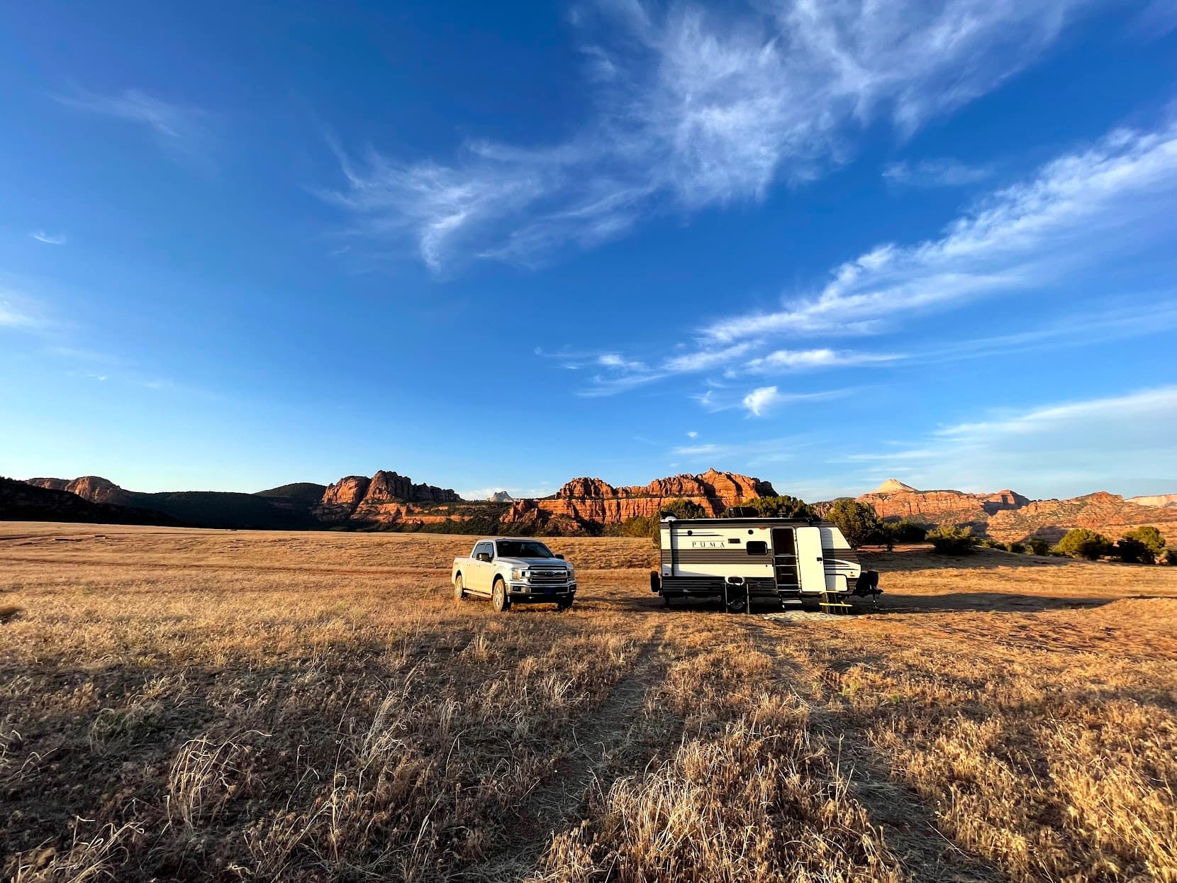 View of a car and RV parked on a plain within a national park on a sunny day