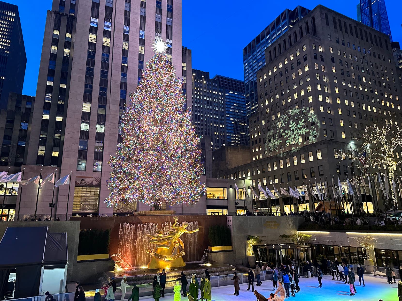 View of the Rockefeller Center Christmas tree and ice skating rink at sundown