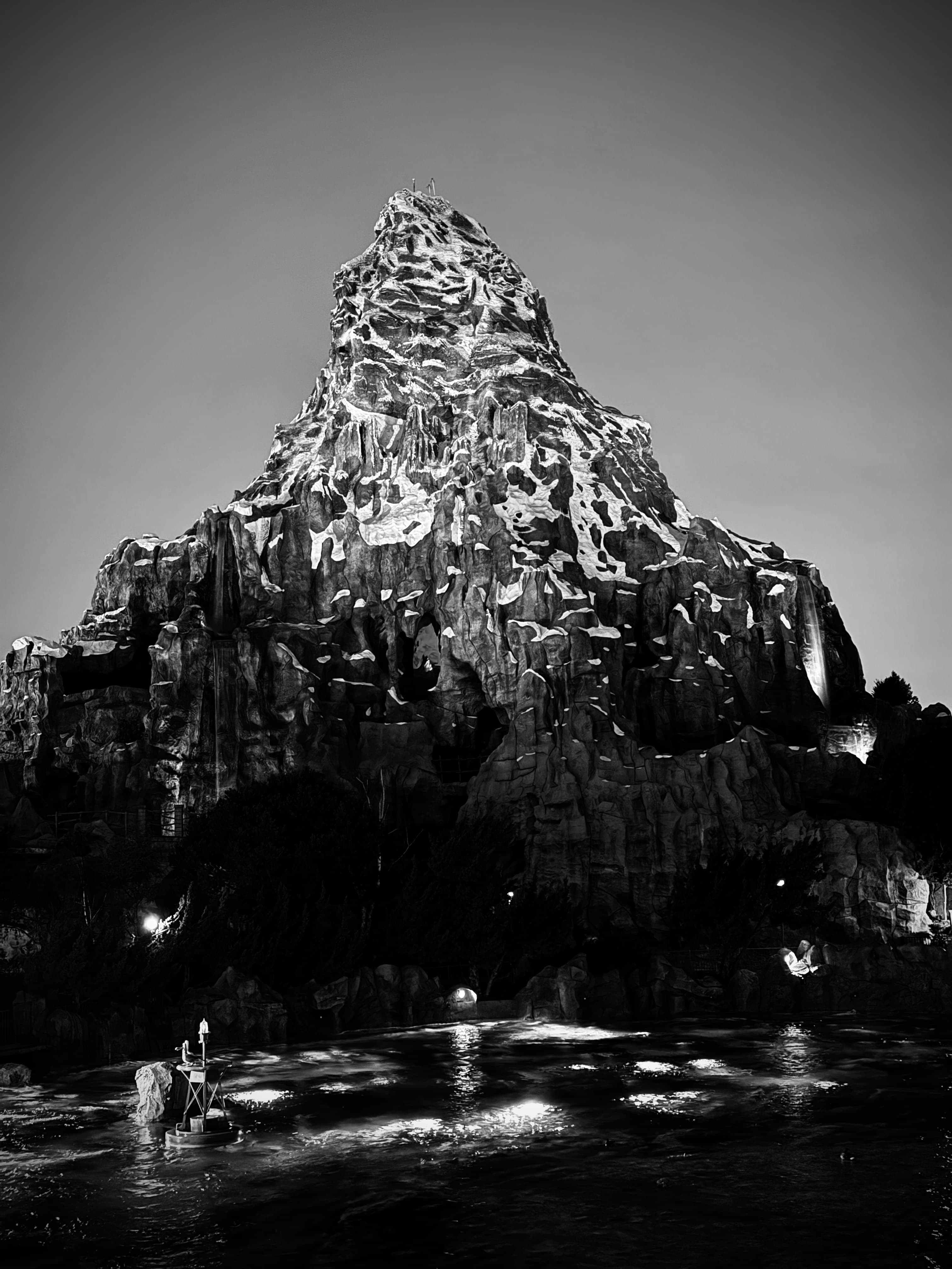 Black and white image of a beautiful mountain rising above the tree tops
