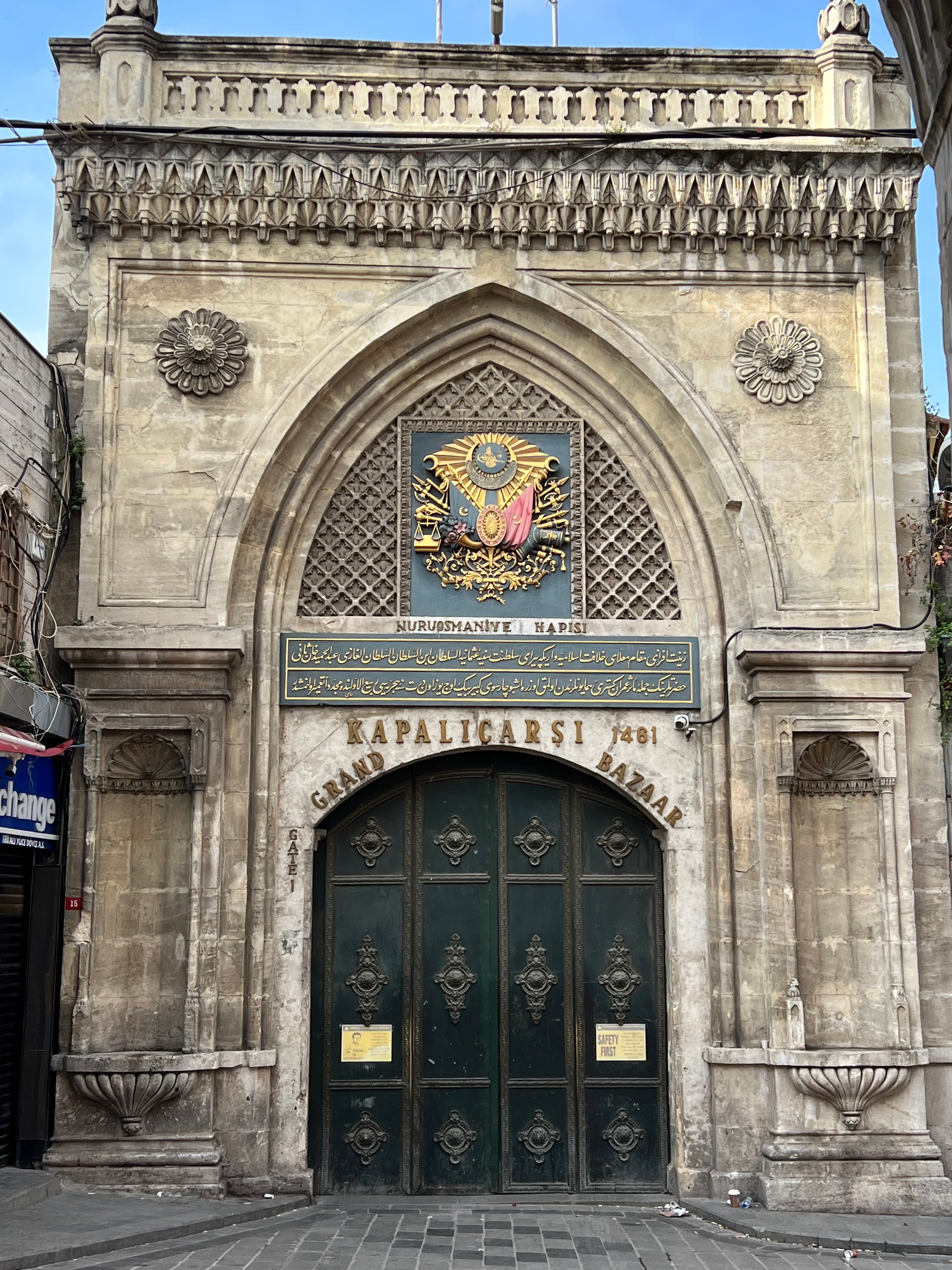 View of an old church with a coat of arms hanging above the dark wooden doorway