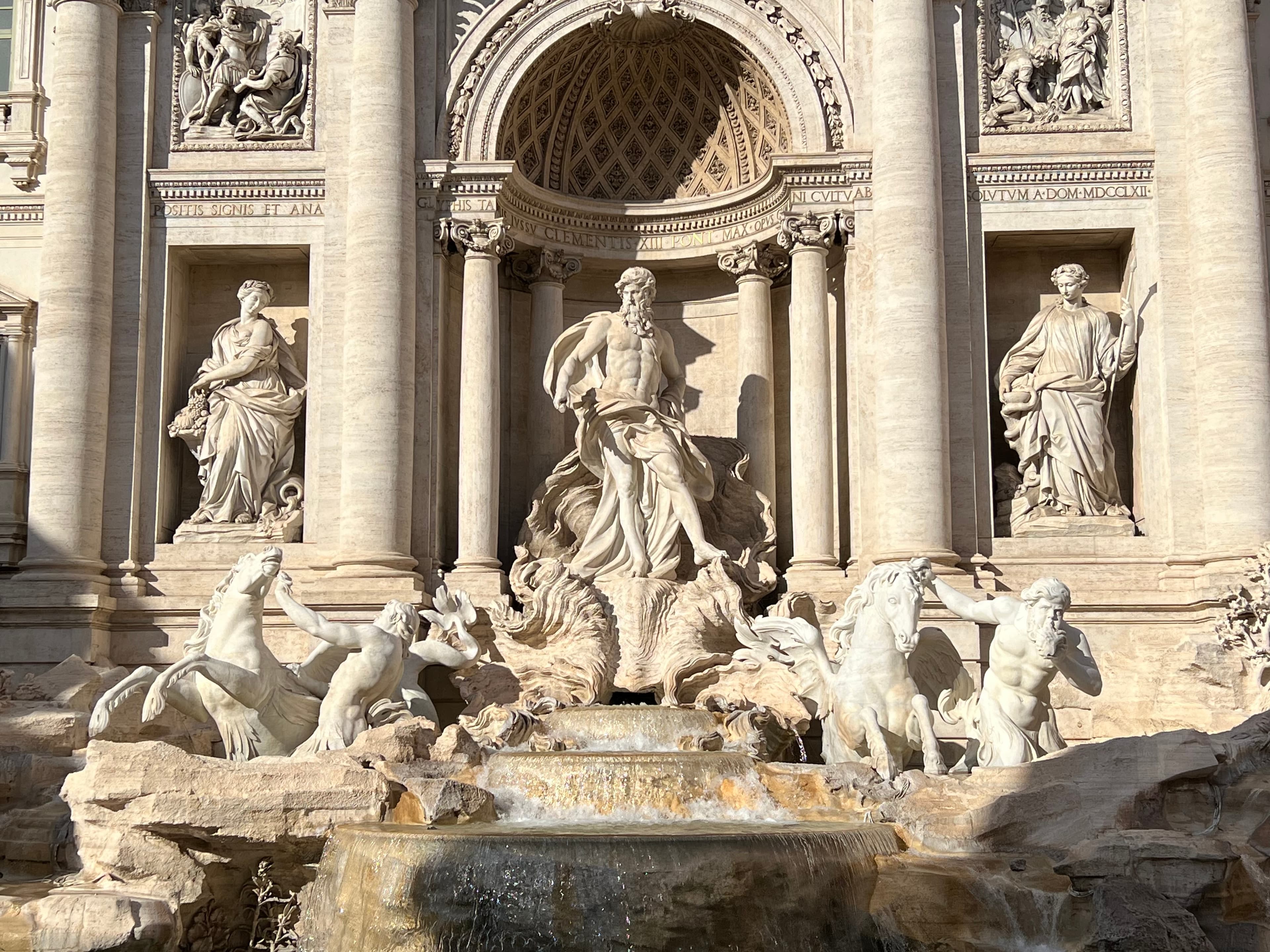 Close up view of the statues above the Trevi Fountain in Rome on a sunny day