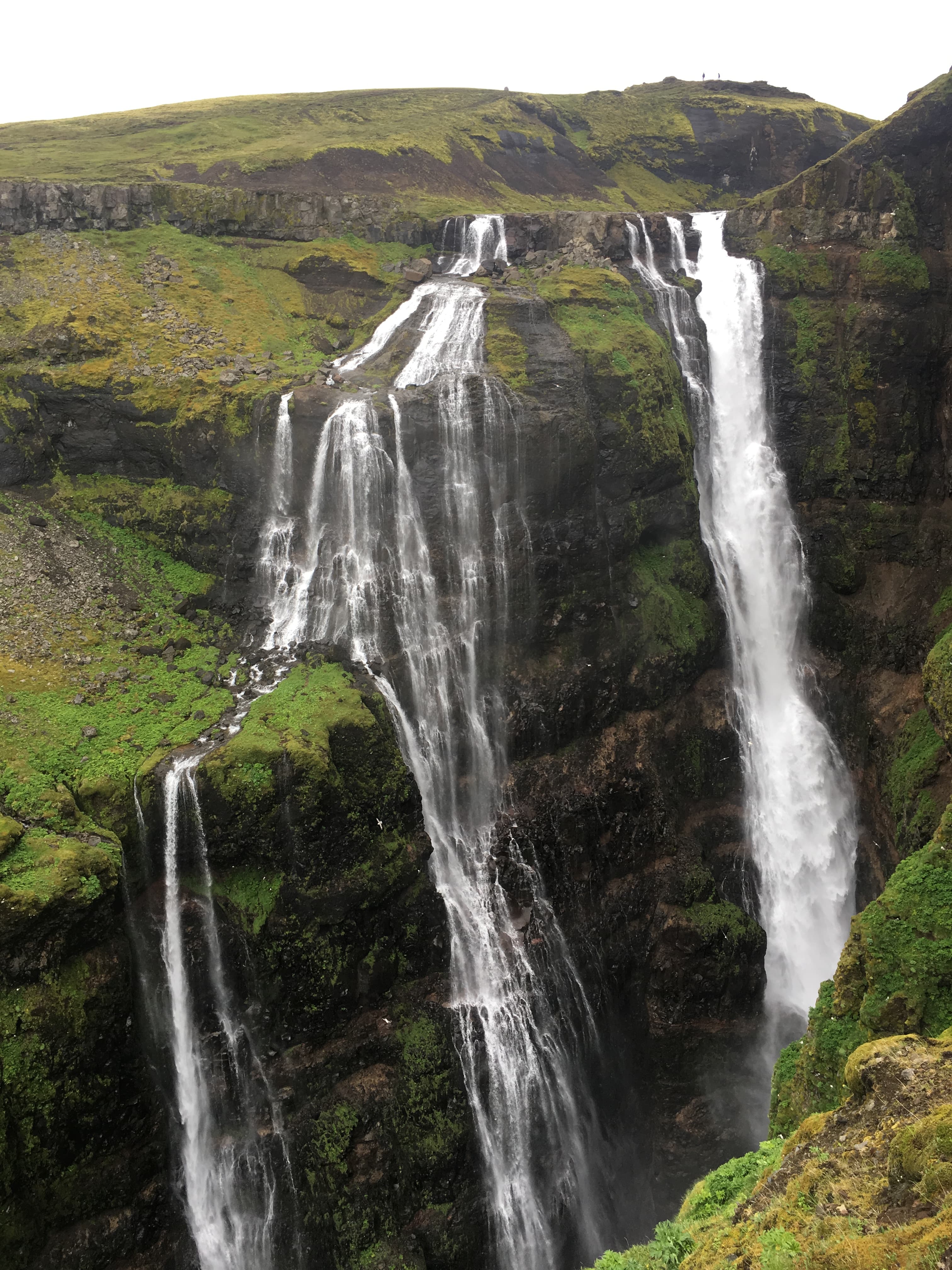 View of a tall and thin waterfall in Iceland on a cloudy day