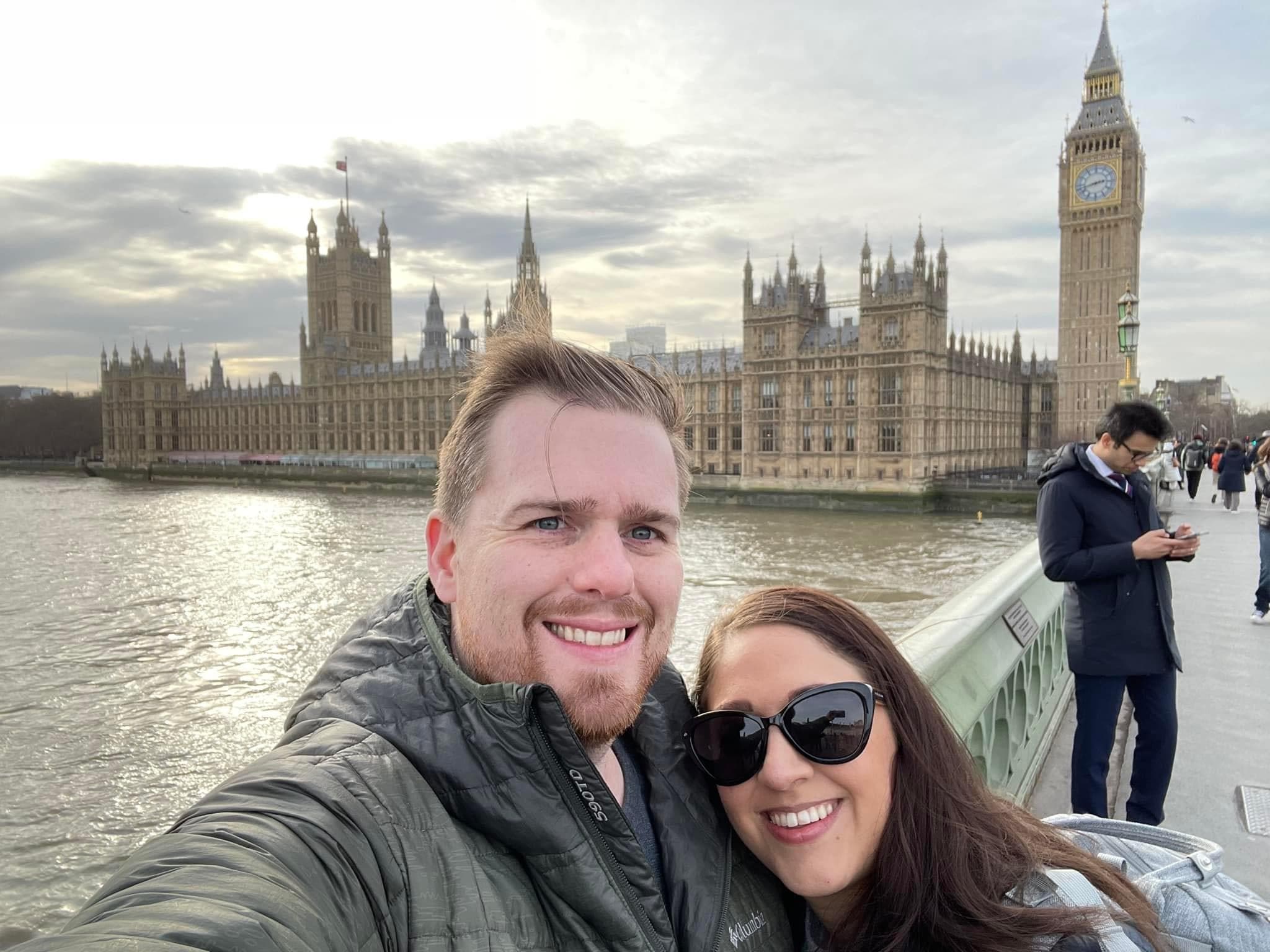 Advisor and partner taking a selfie on a bridge in London with Big Ben visible in the background