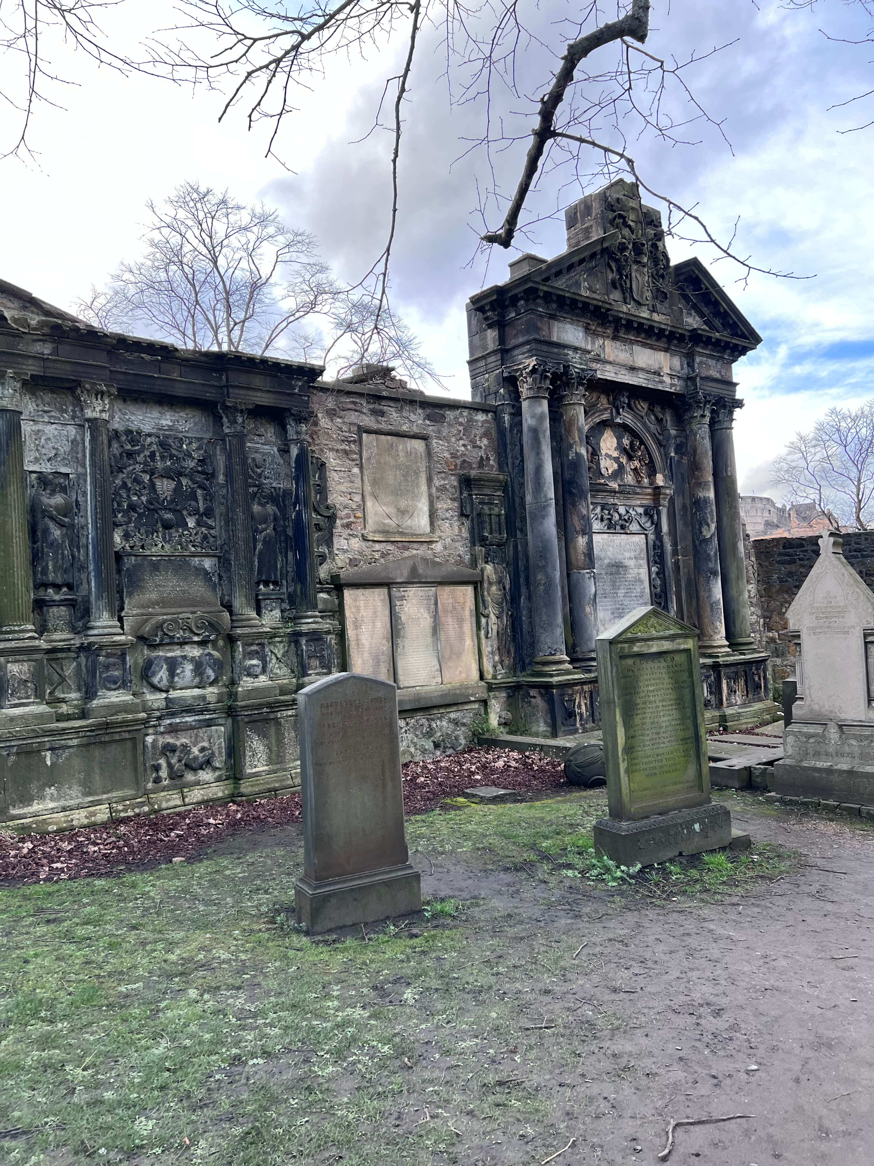 View of two old tombstones at a cemetery on a cloudy day