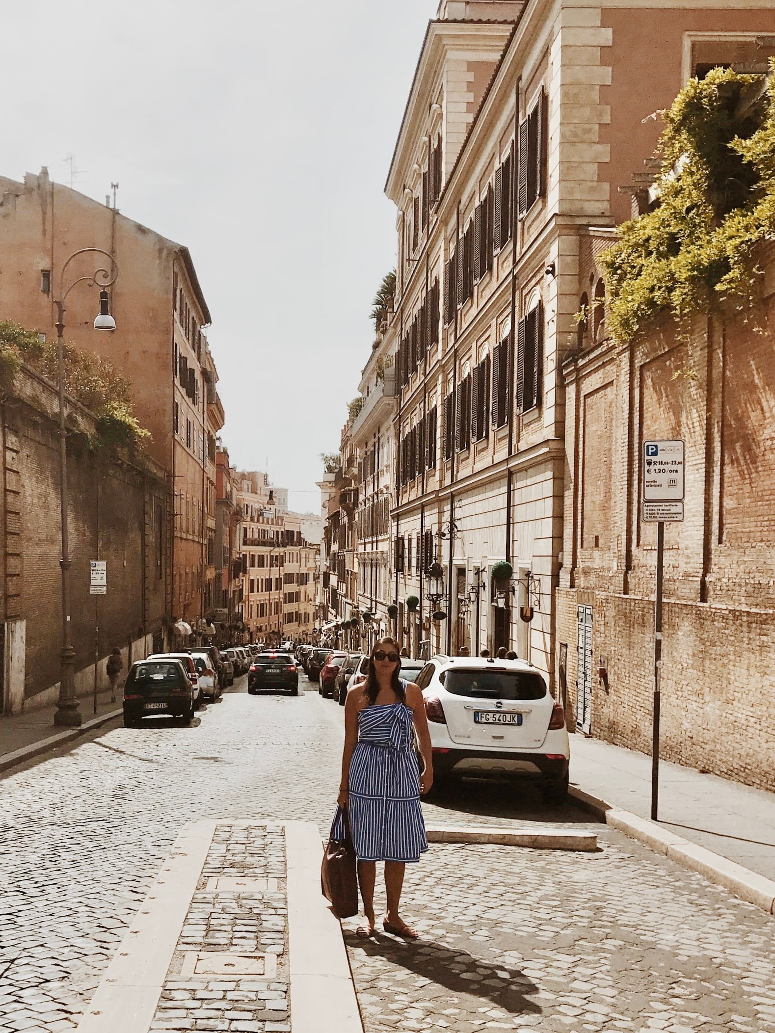 Advisor in a blue and white dress on a cobblestone street in an old city on a sunny day