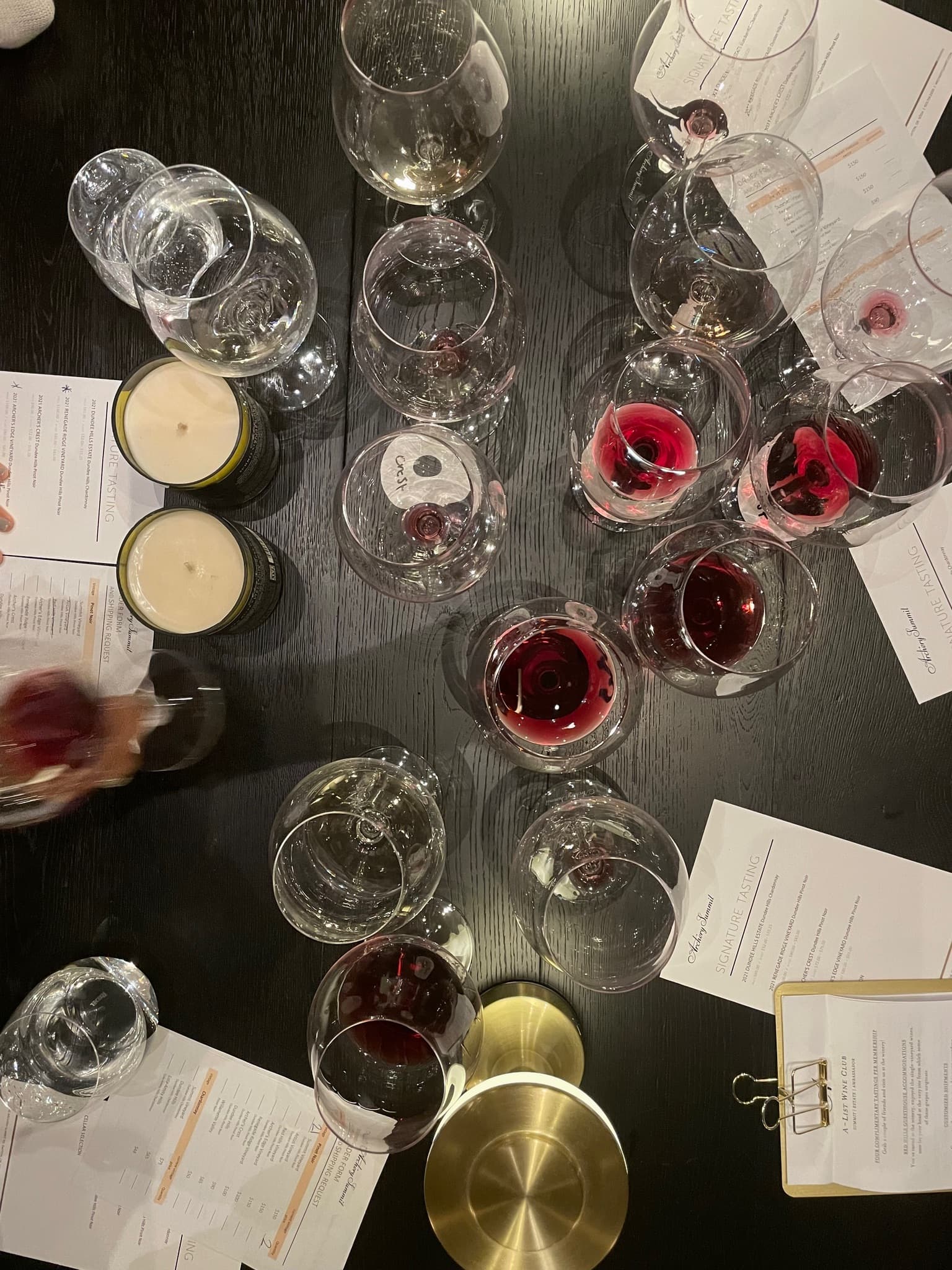 Overhead view of a black table with several glasses of wine and beer