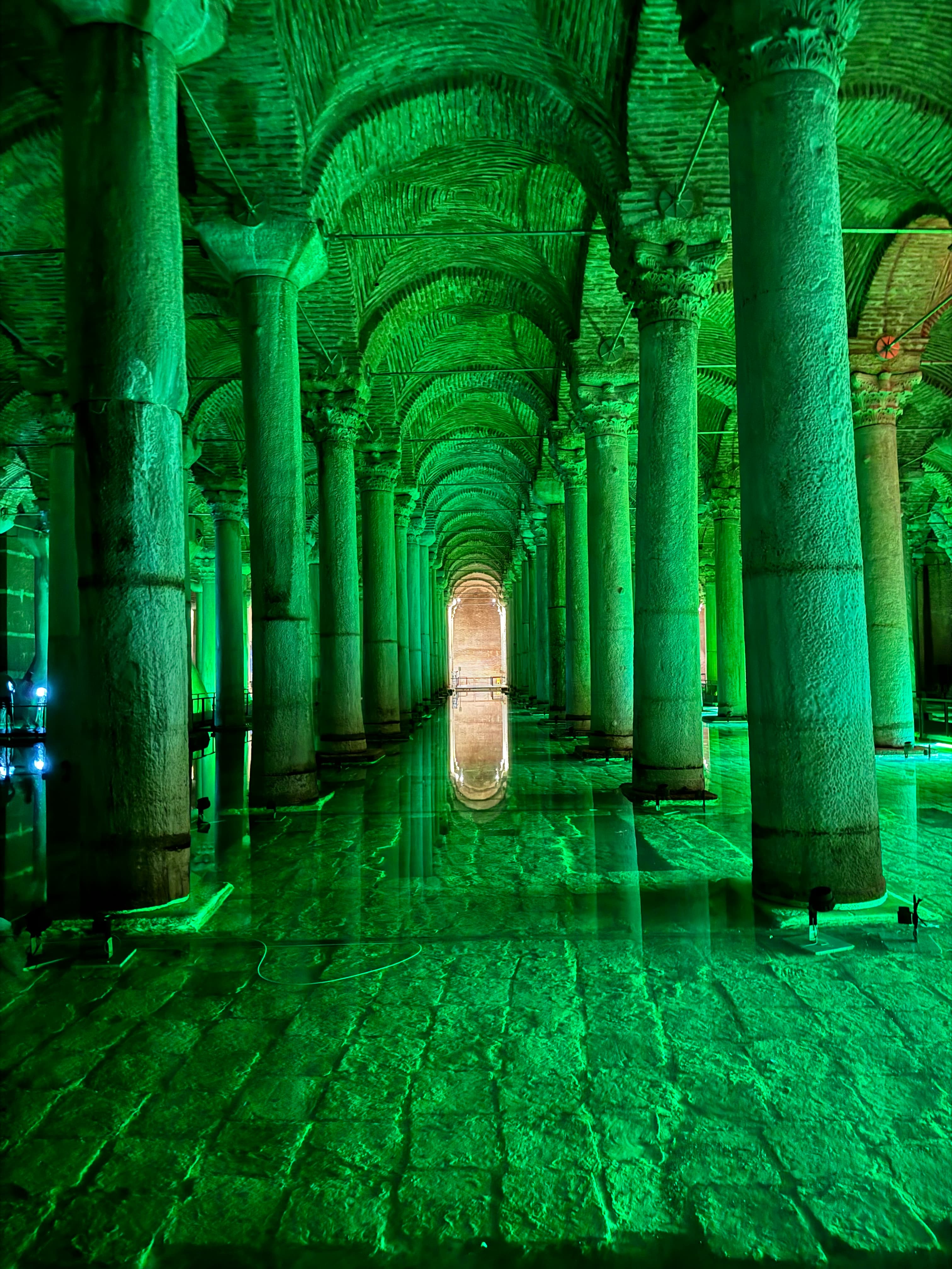 View of an old hall lined with columns and lit with green light
