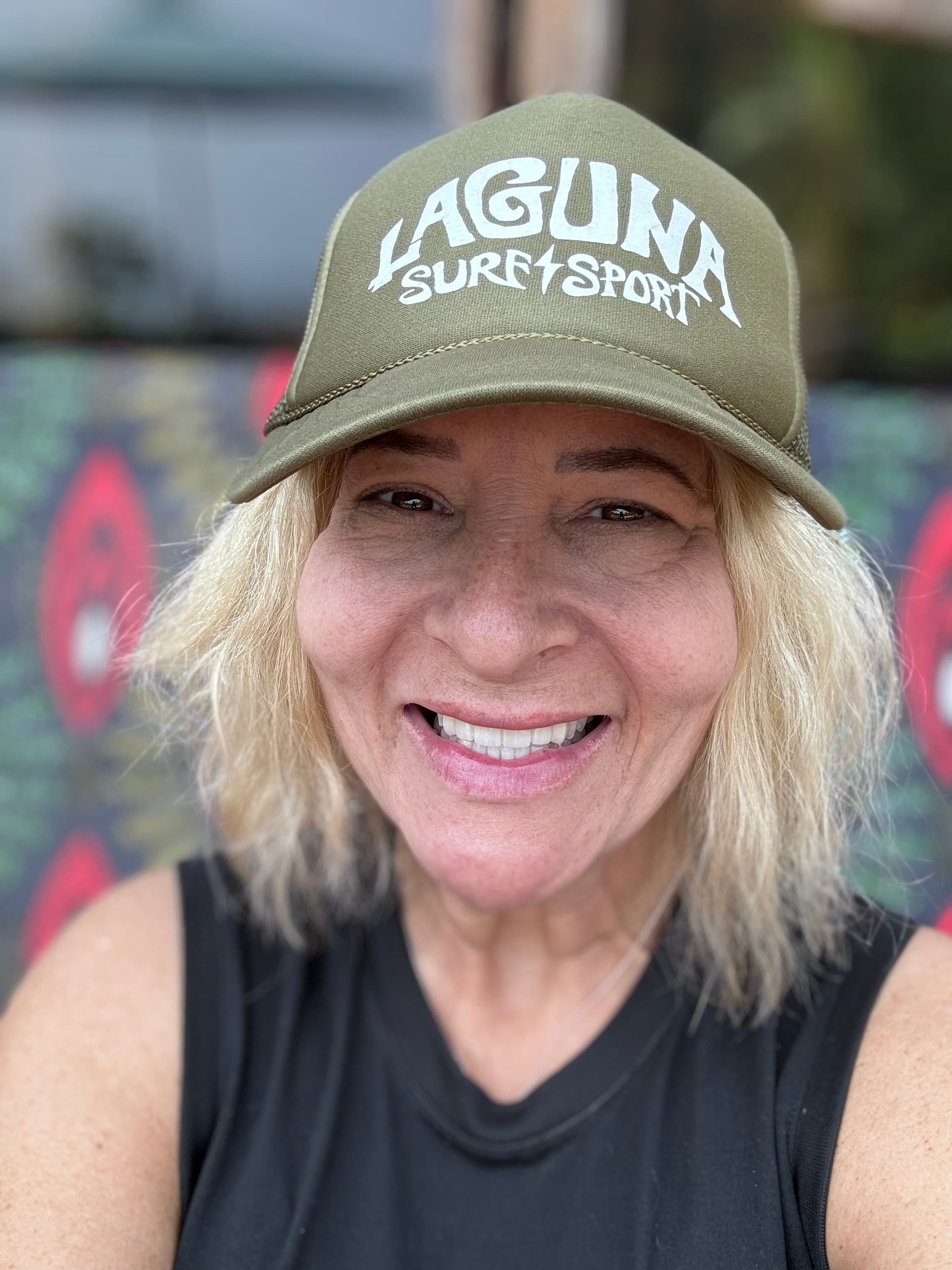 Advisor smiling for a selfie in a baseball cap from Laguna Surf Shop