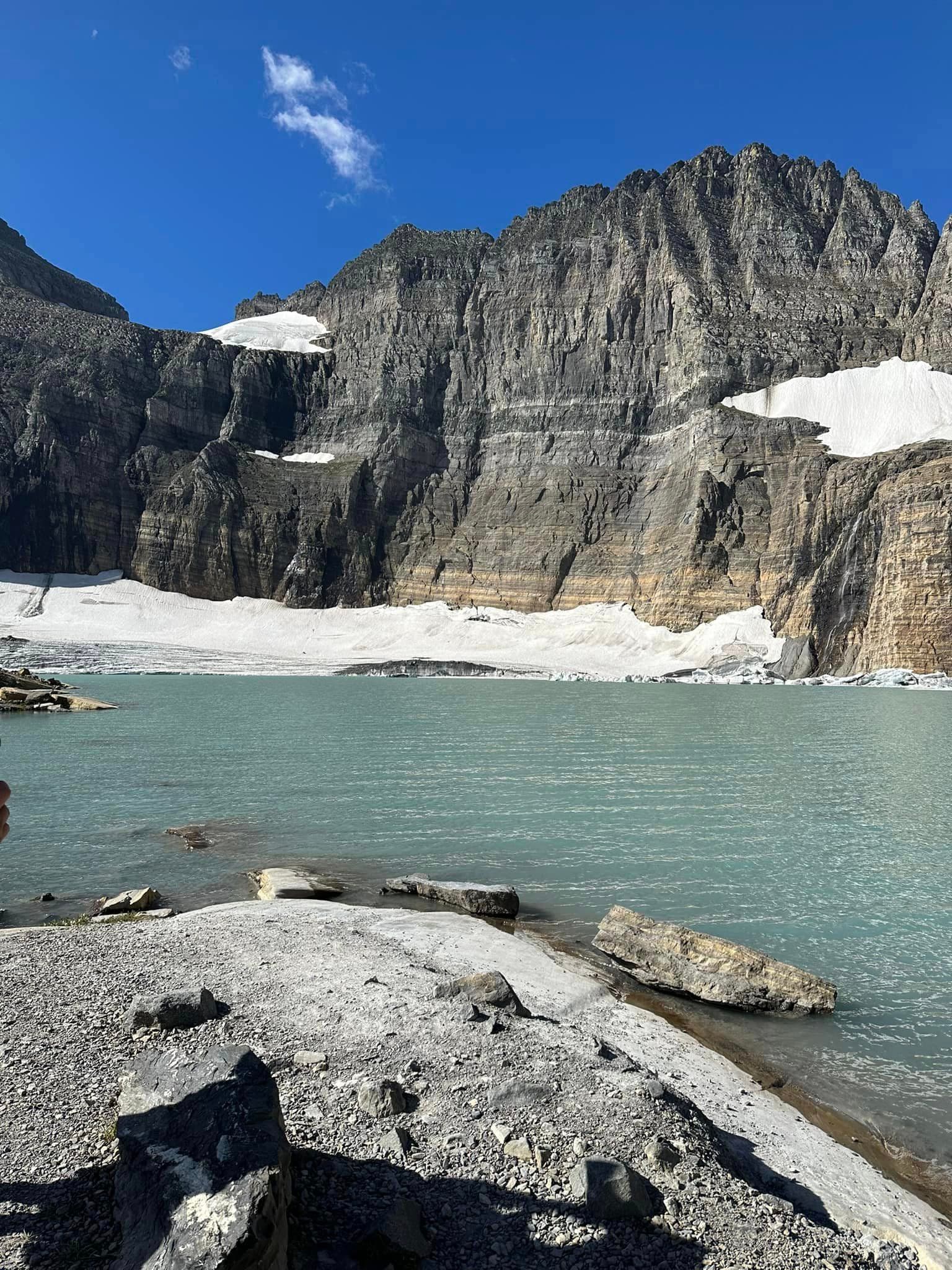 A body of water with a mountain next to it during the daytime
