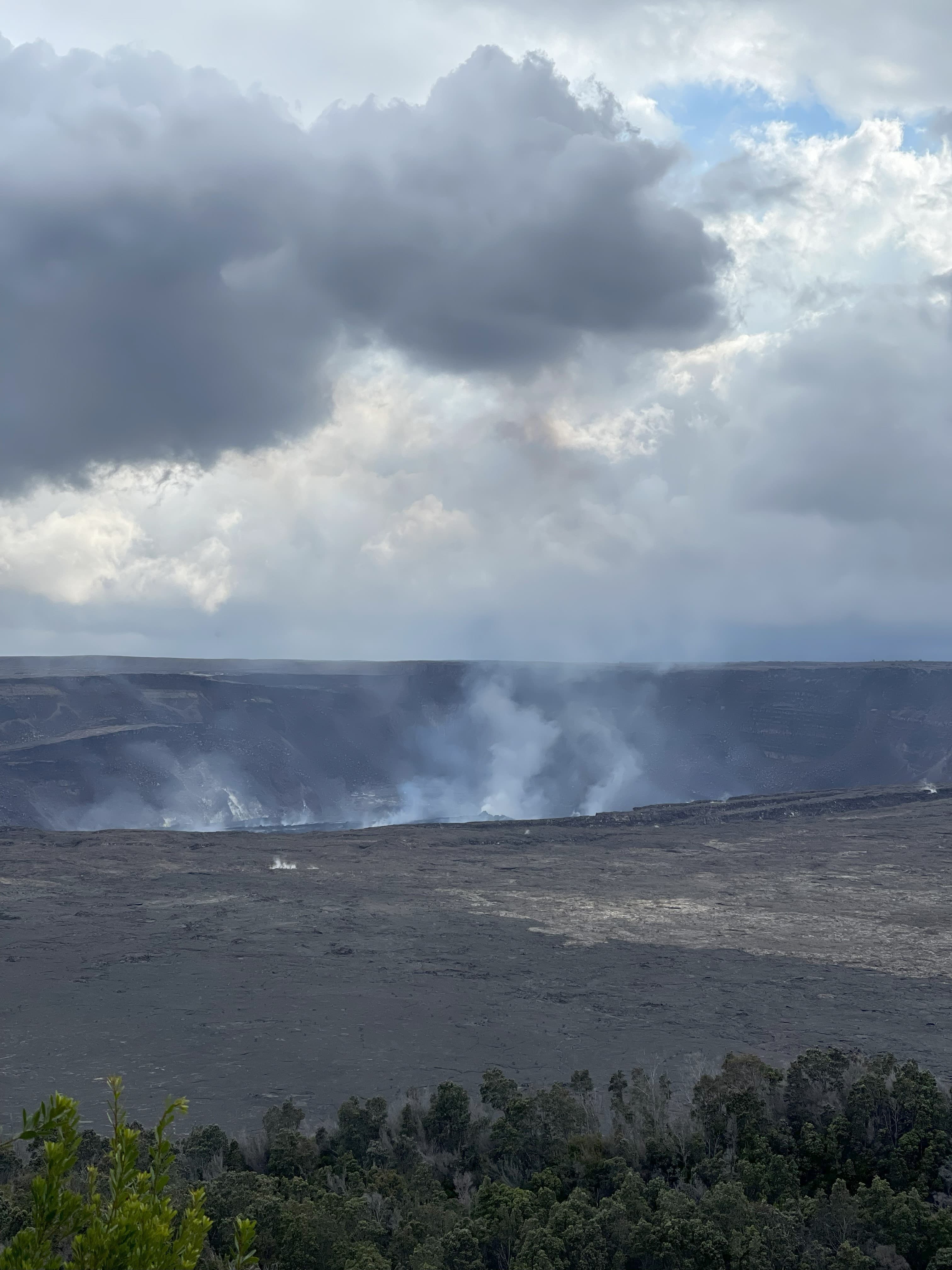 View of steam rising from a volcano’s crater on a cloudy day