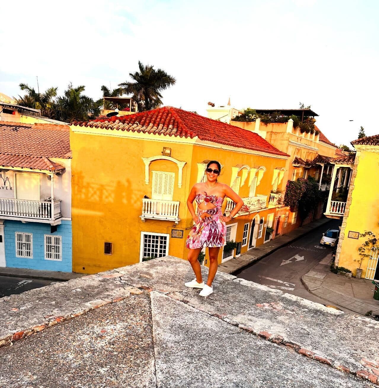 Alexa posing on top of a colorful building during the daytime.