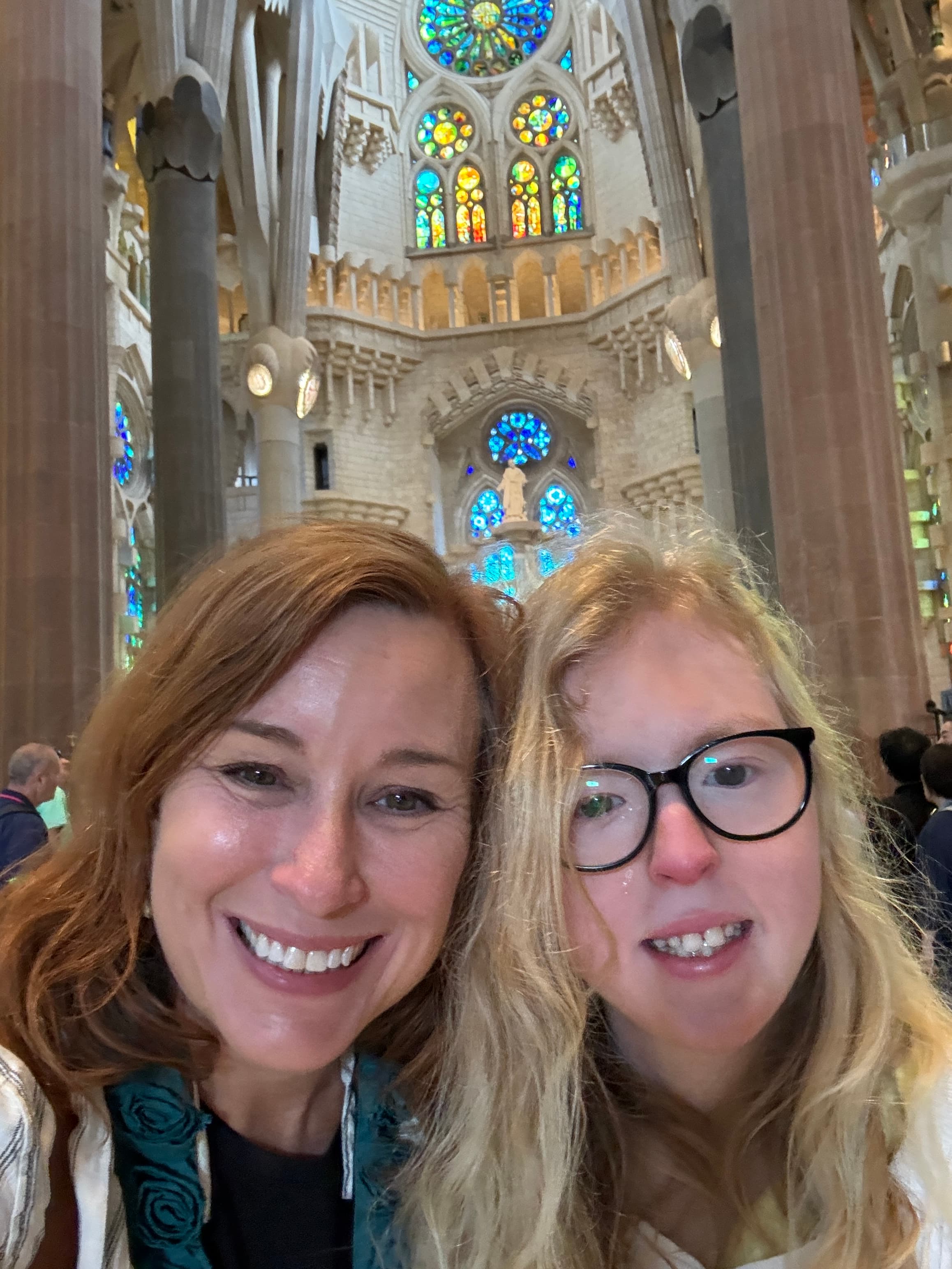 Advisor and daughter taking a selfie in a large cathedral with stained glass windows
