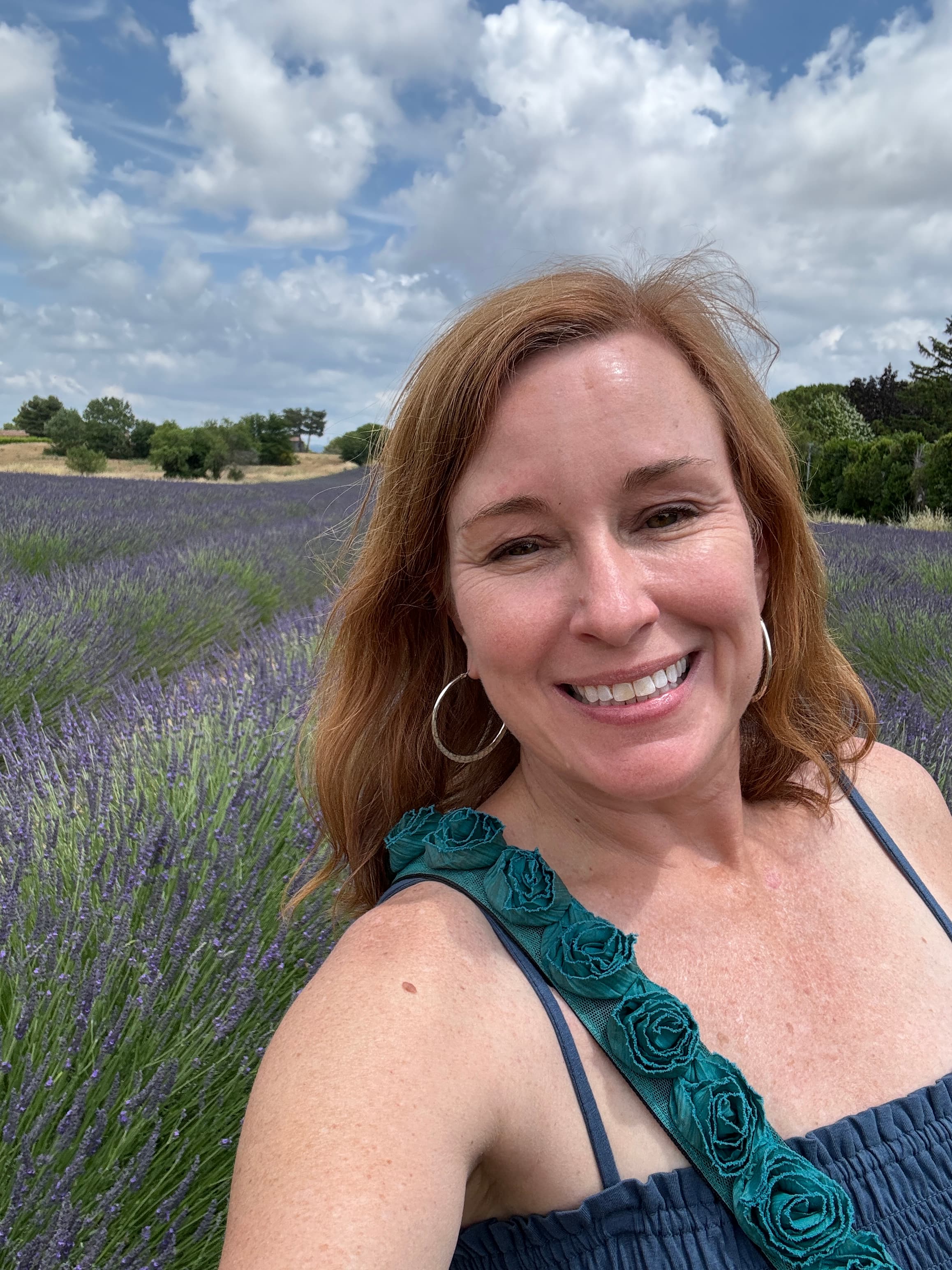 Advisor in a green dress taking a selfie in a field of lavender on a sunny day