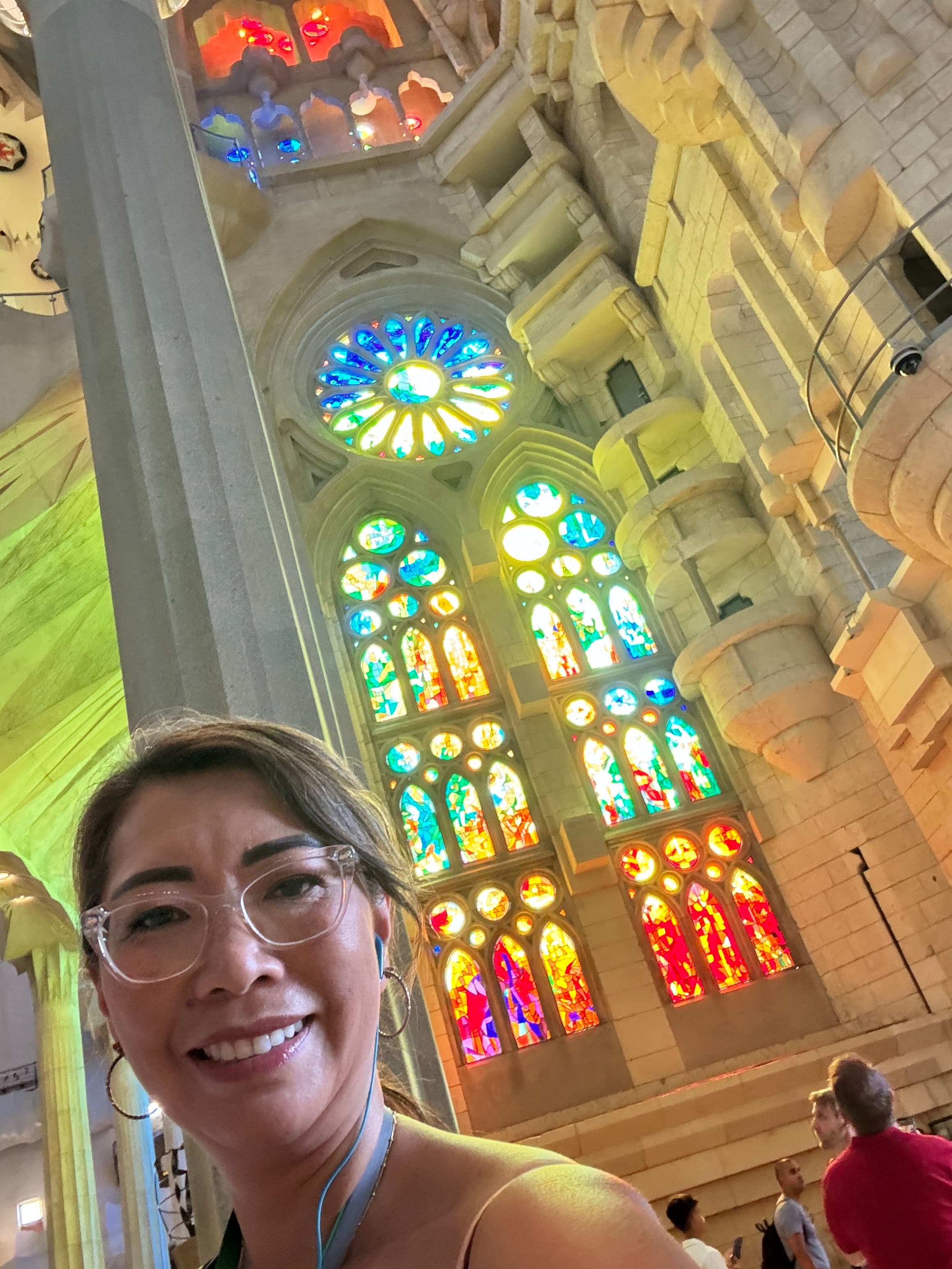Advisor posing for an image inside of a well lit building with stained glass windows.