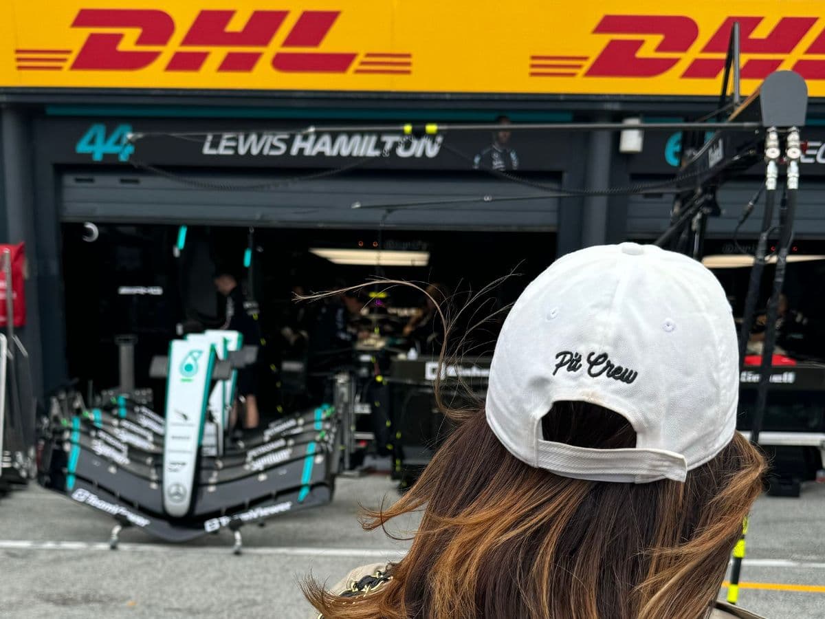 A view of a race track with a team in the distance on a sunny day.