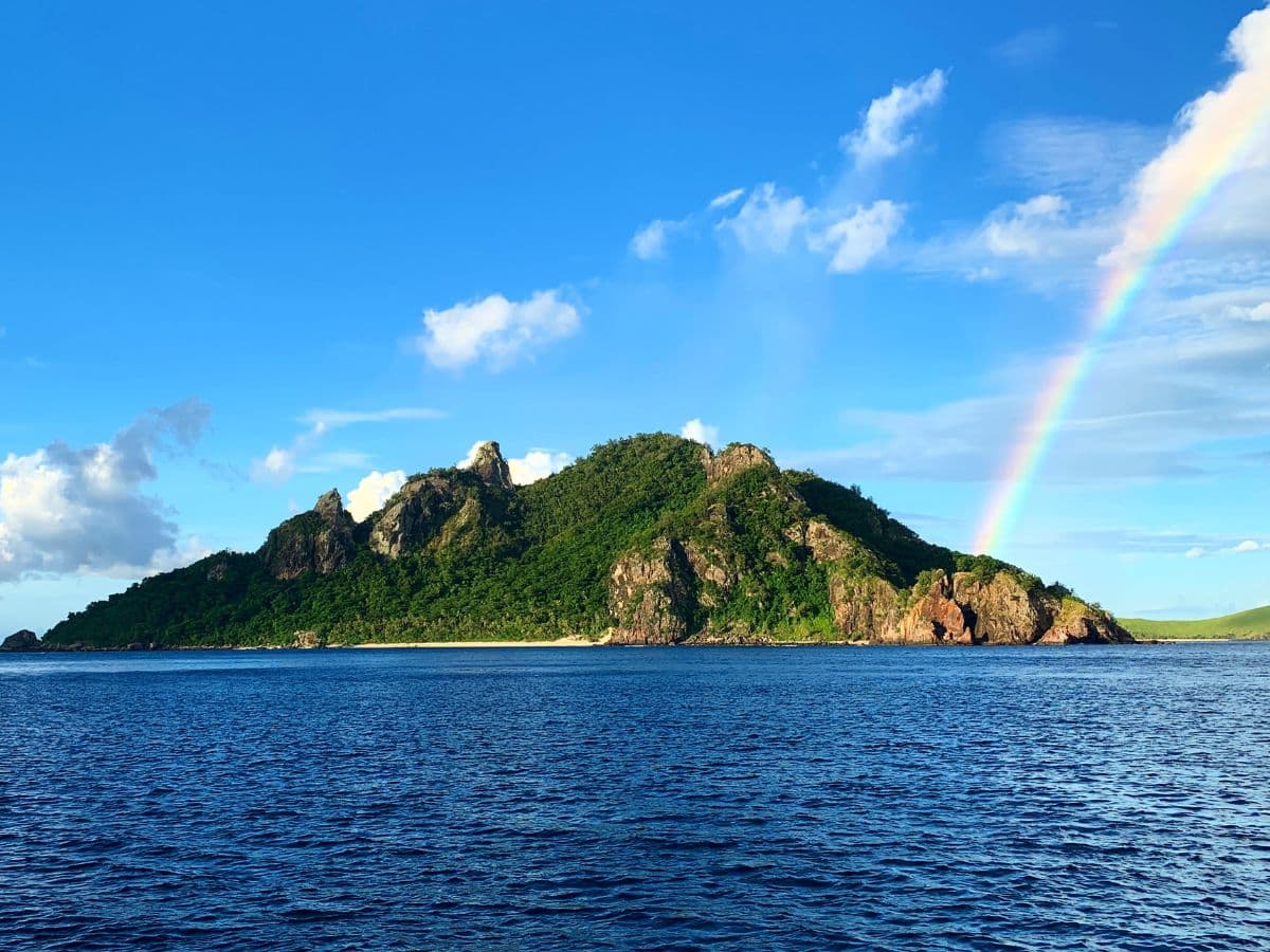 A view of the ocean with an island in the distance on a sunny day.
