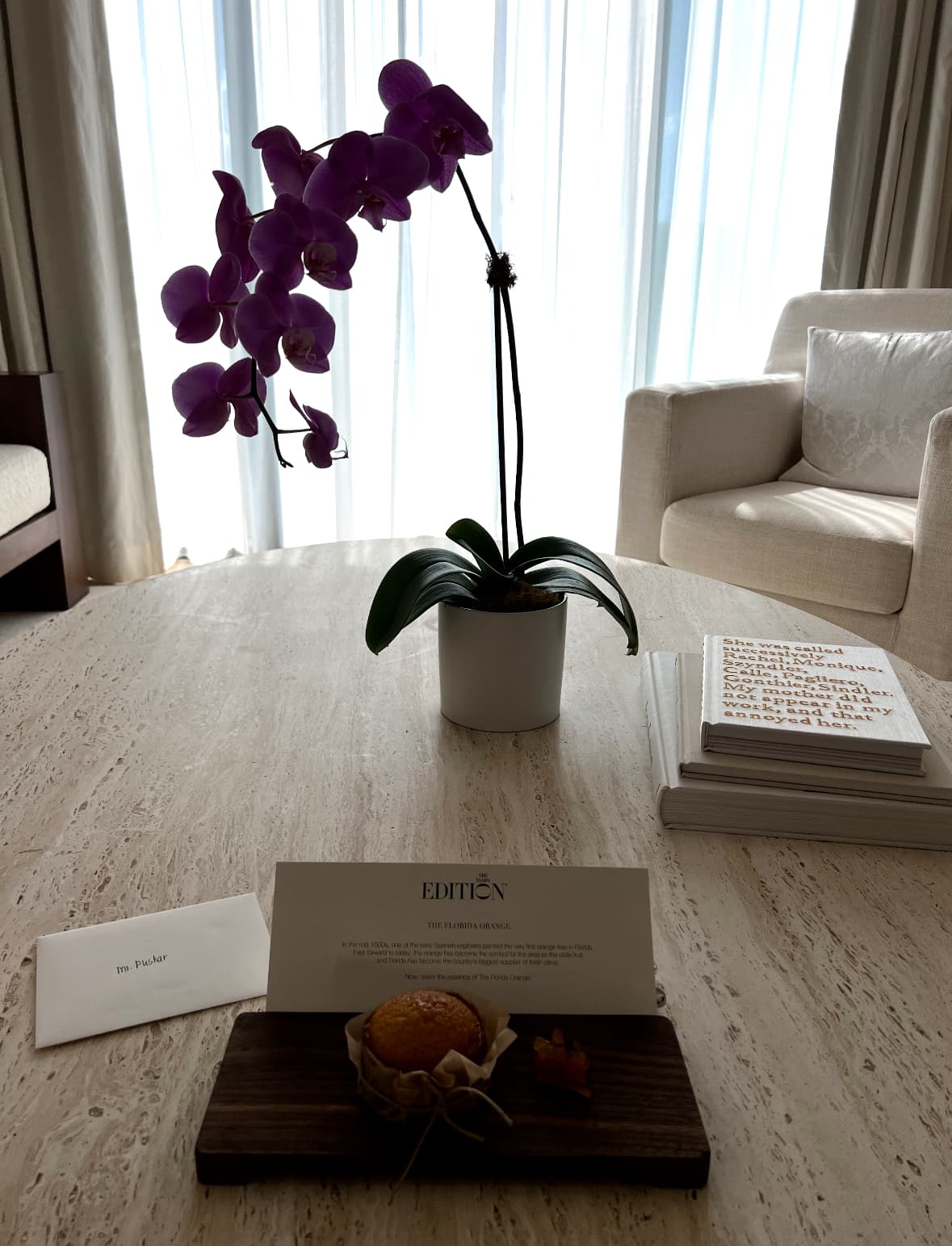 An image of an orchid inside a hotel room with a lovely, personalized welcome note.