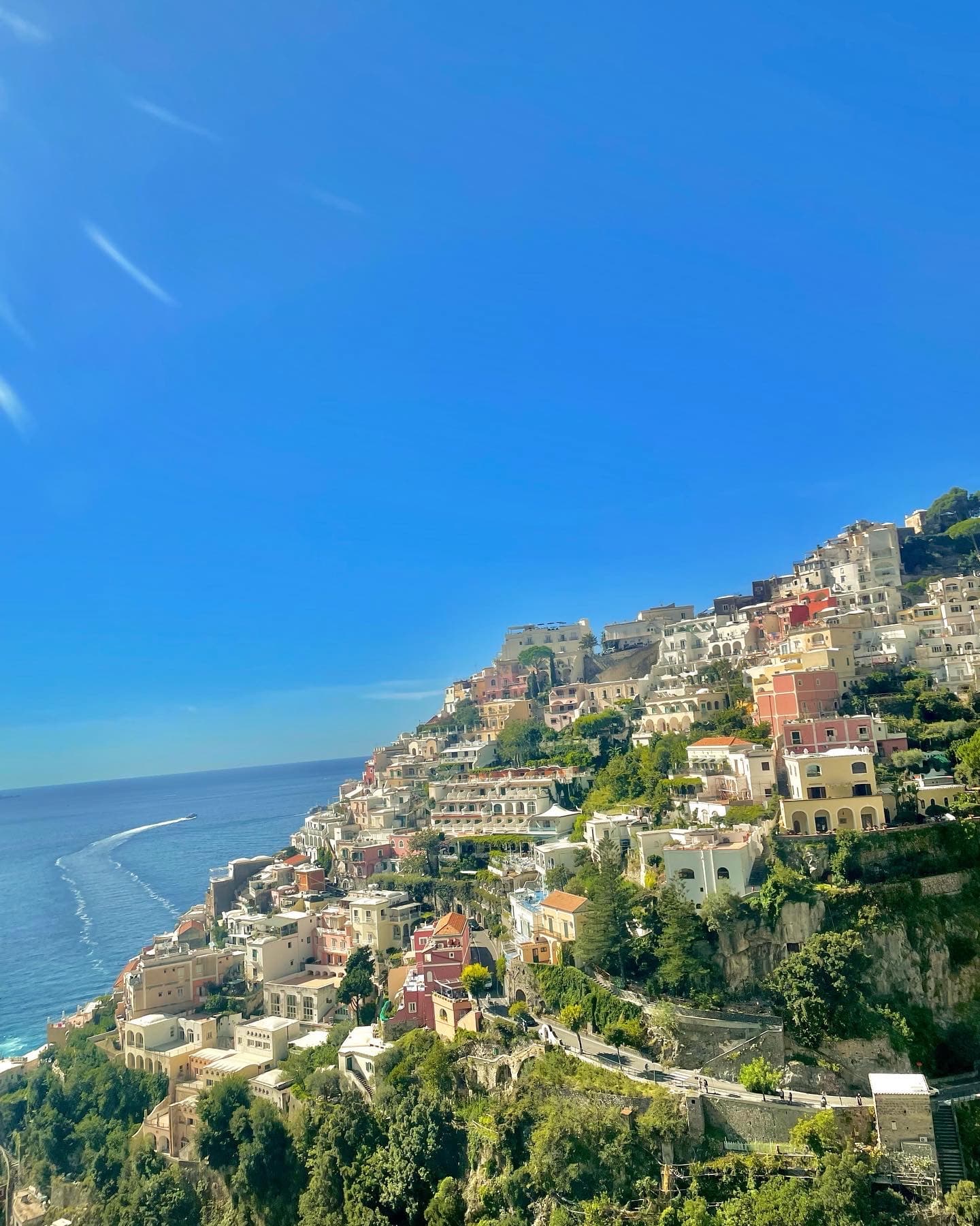 A view of the ocean and a seaside town during the daytime.