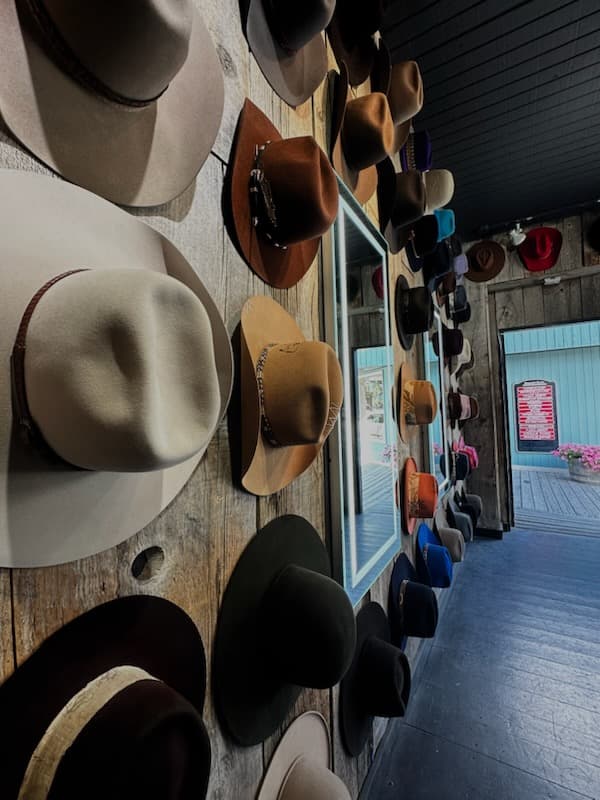 View of several cowboy hats hanging in rows on a wall