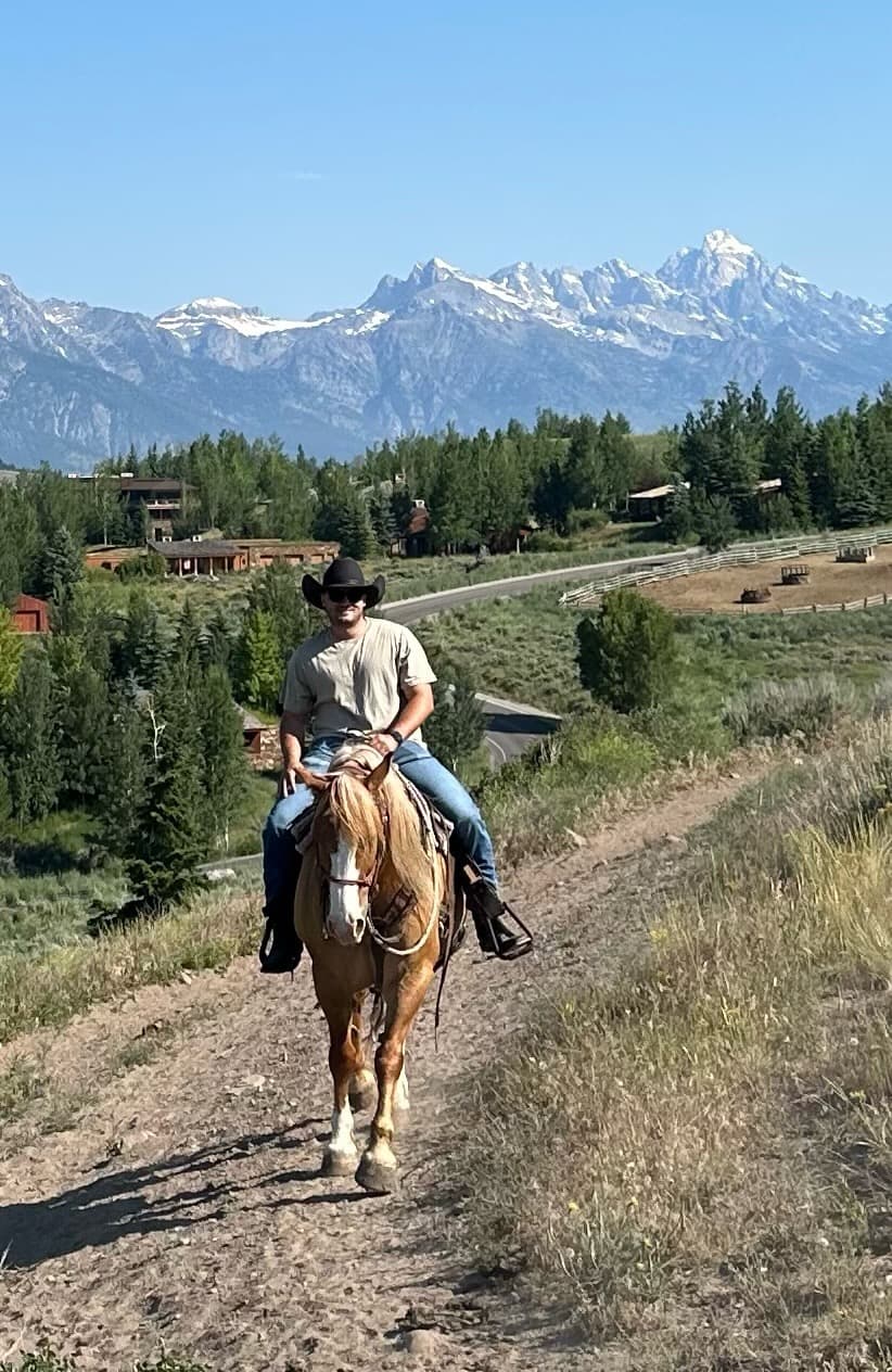 Advisor on horseback in the mountains on a sunny day