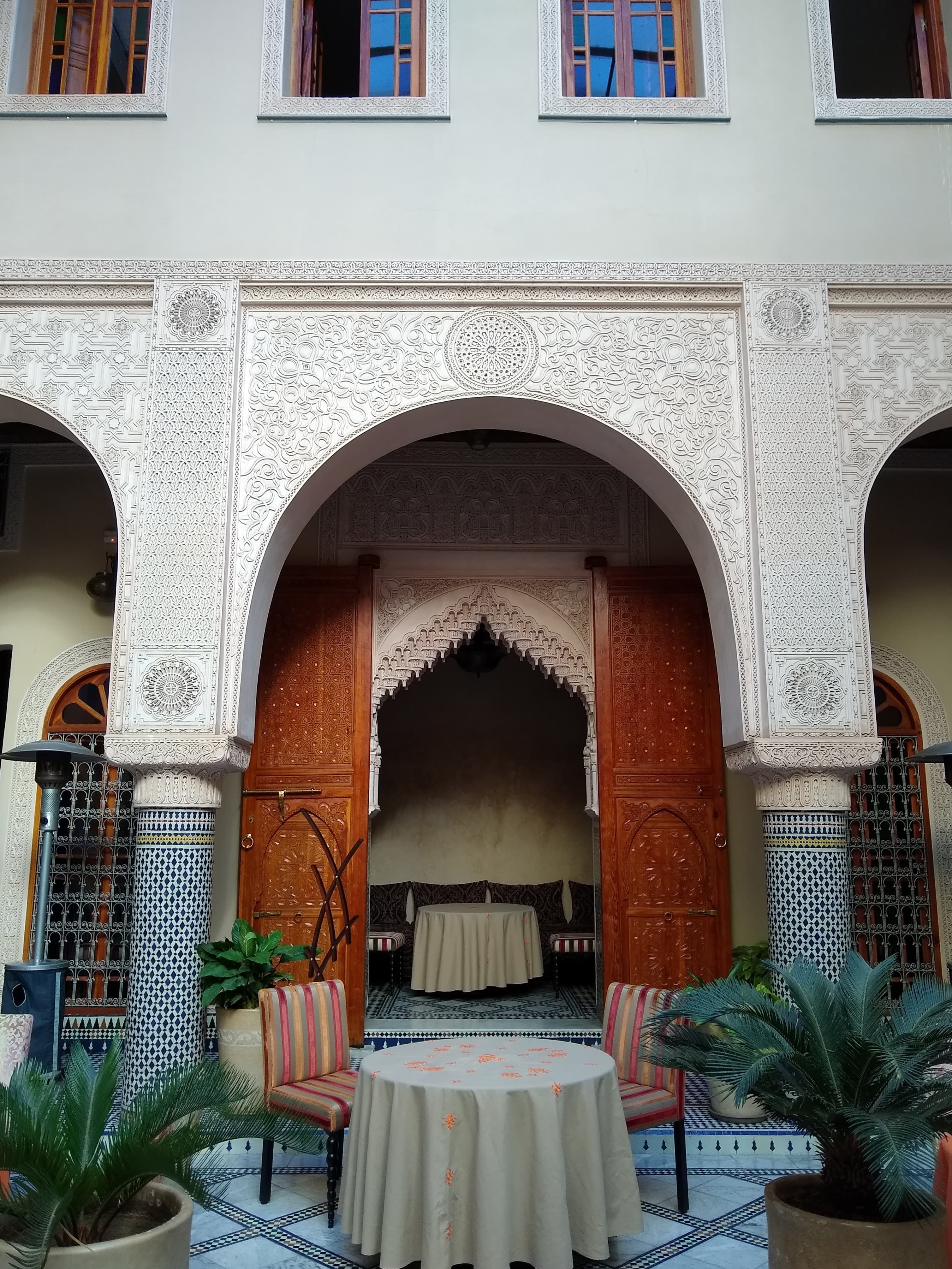View of a table and two chairs in a beautiful interior courtyard with potted plants to either side