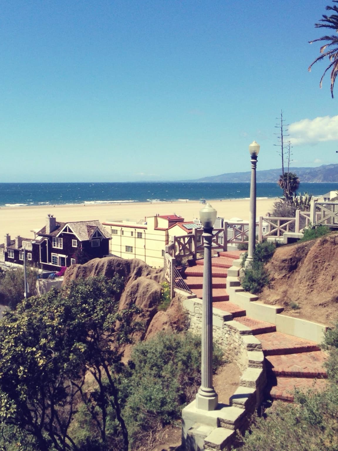 View of a staircase leading down towards the beach on a sunny day
