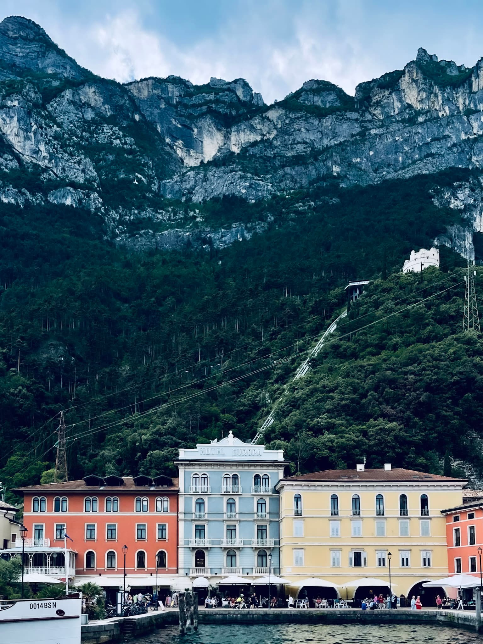 View of three colorful buildings on the waterfront with towering mountains behind them