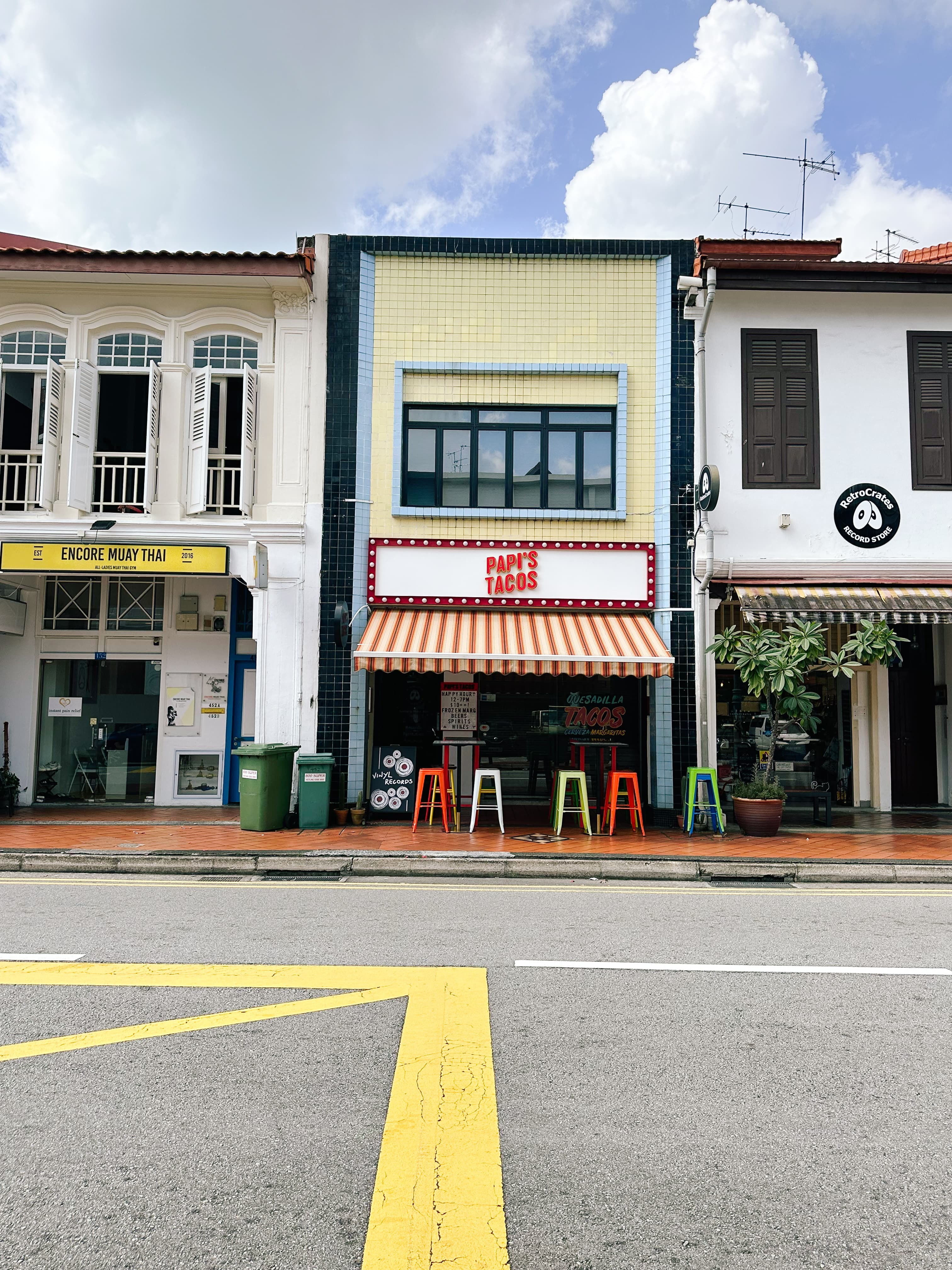 View of three small storefronts in a quaint town on a sunny day