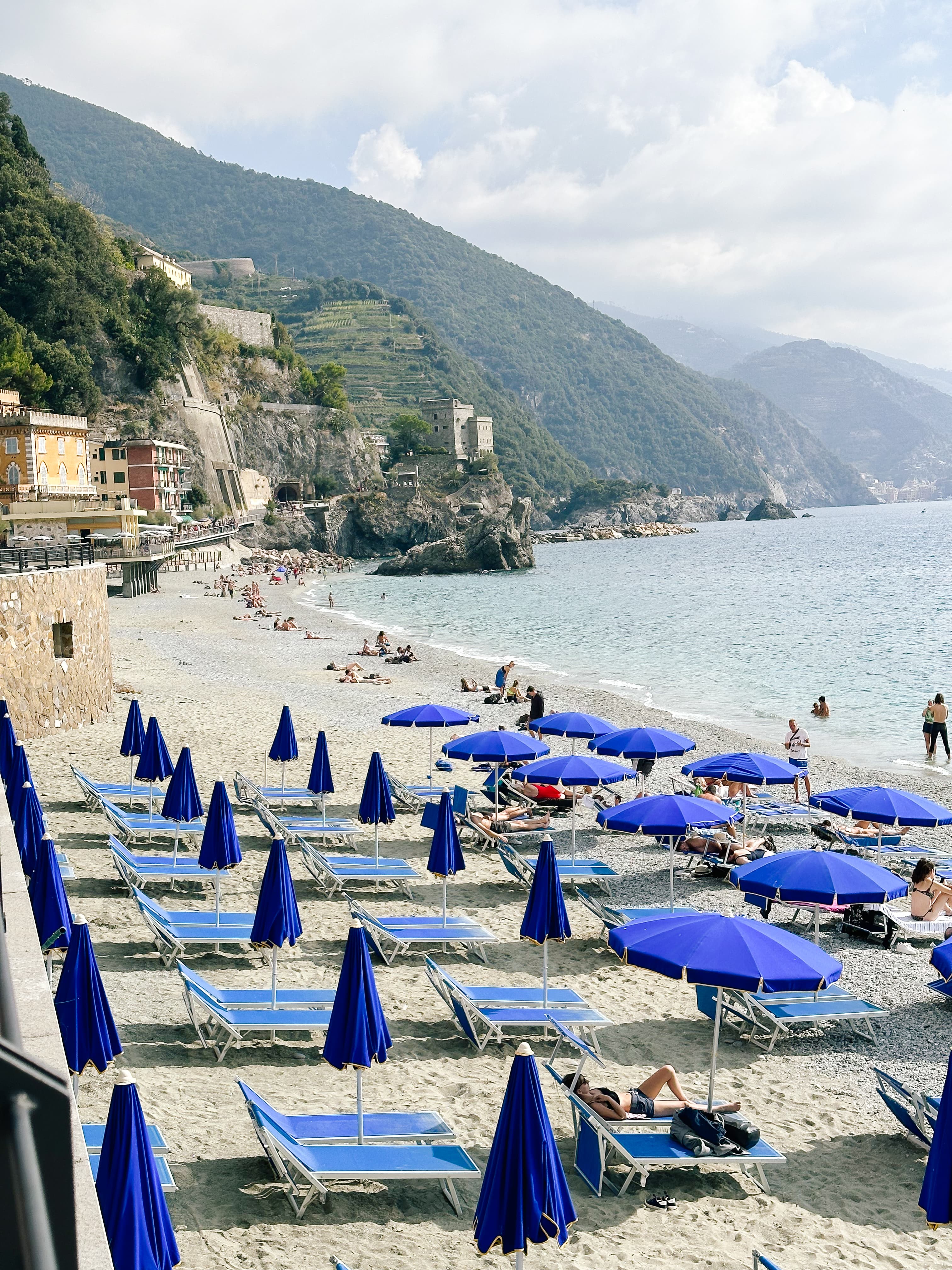 View of blue lounge chairs and umbrellas on a beach during the day