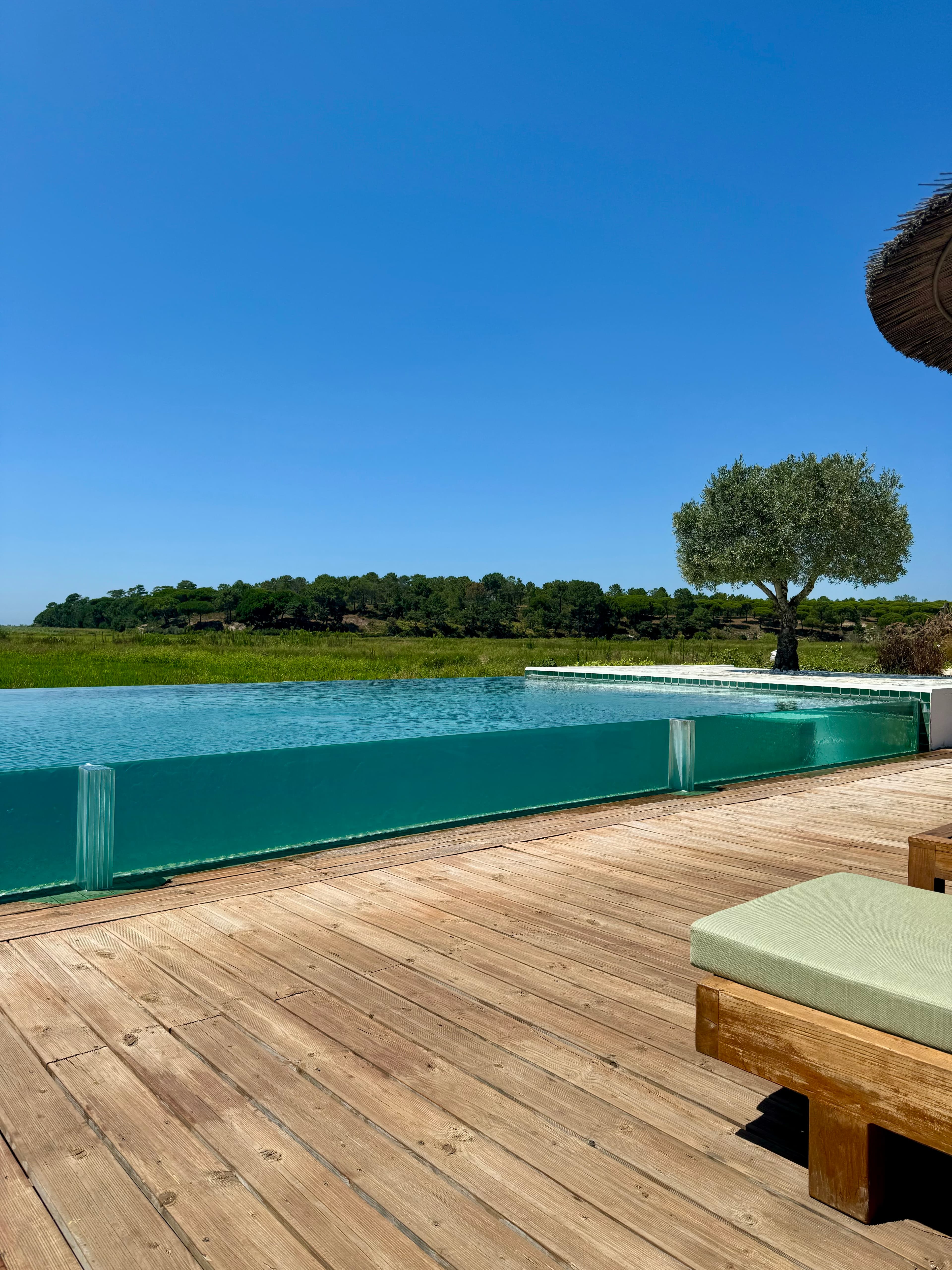 View from the side of an infinity pool at a resort on a clear day
