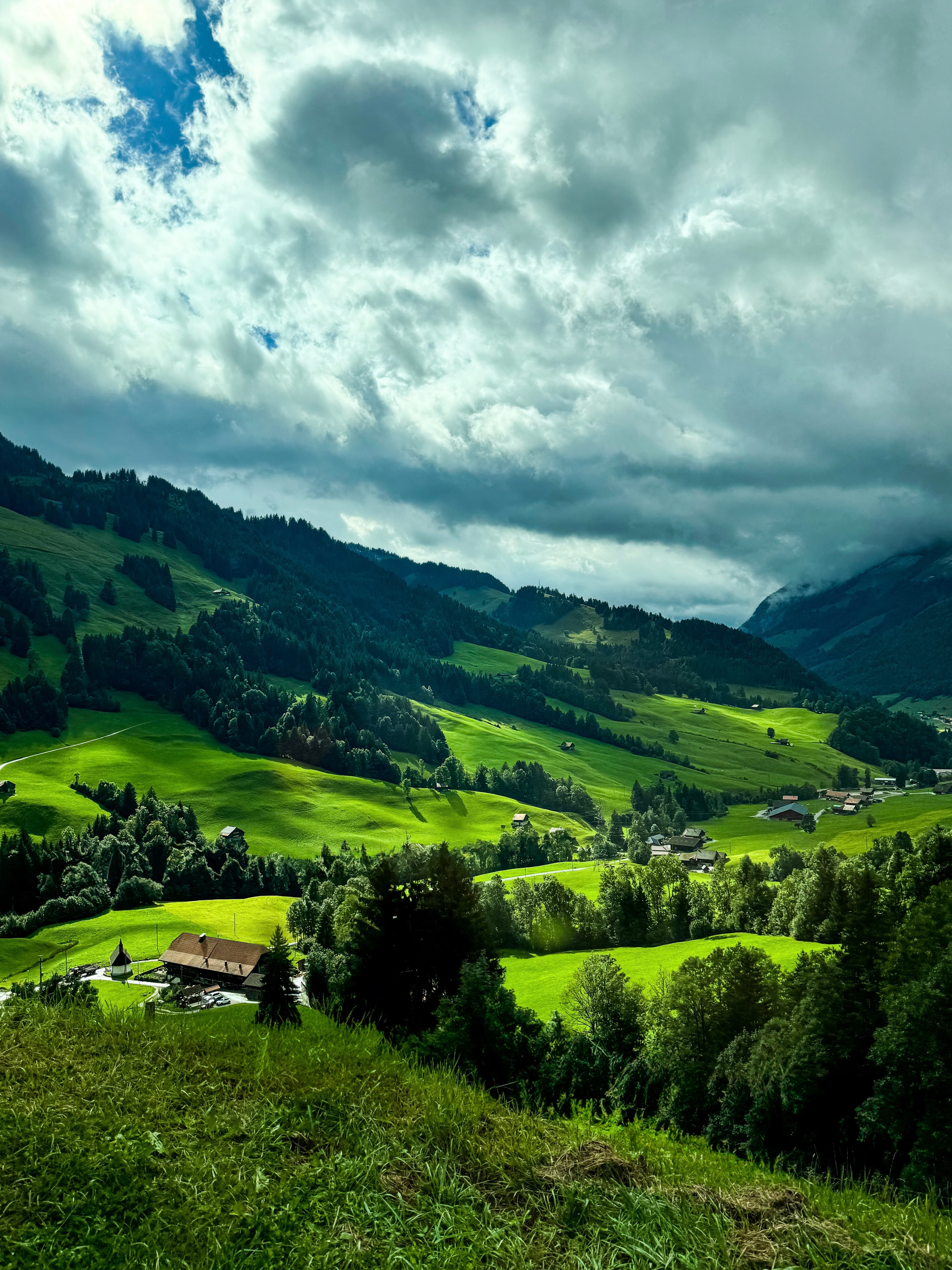 View of a beautiful lush green valley with a few small buildings visible throughout